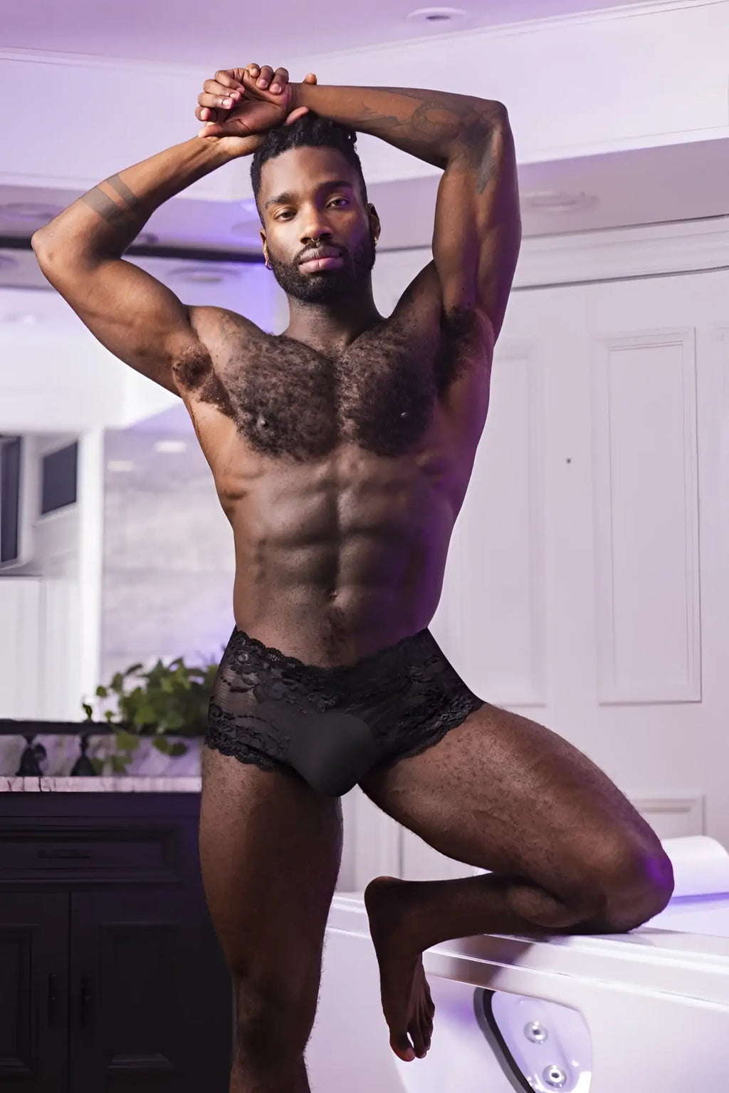 Black lace-trimmed Male Power sassy lace mini short briefs in sheer black material with a supportive pouch