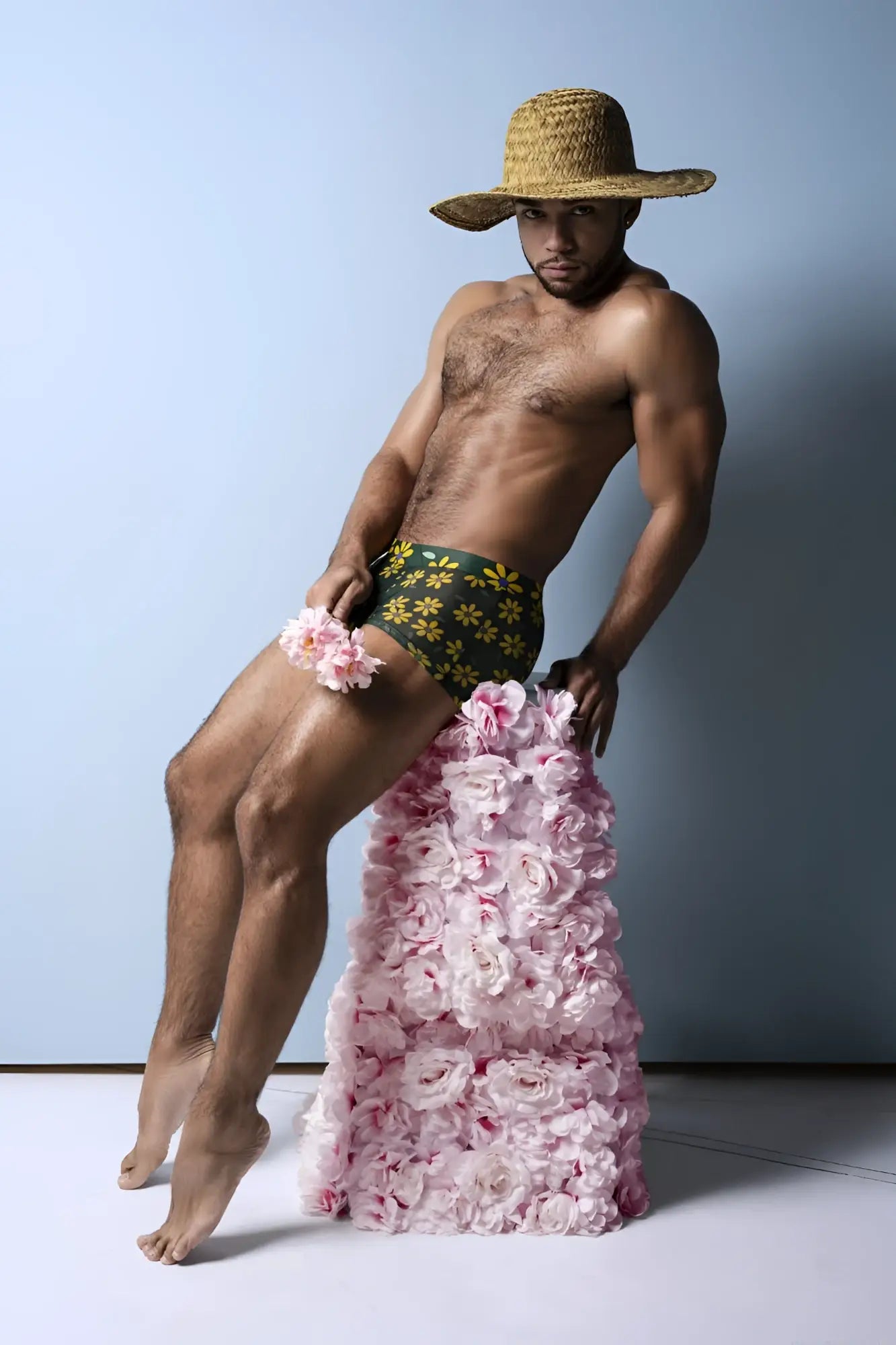 A man wearing male power petal power pouch short in daisy print green briefs with pink roses cascading down legs