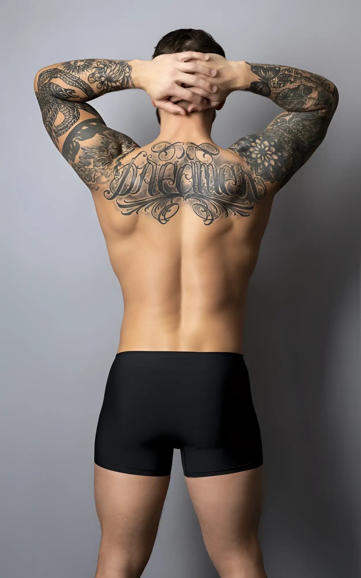 A man wearing male power 154-300 hot mesh pouch short black-red showing extensive black tattoos on back side