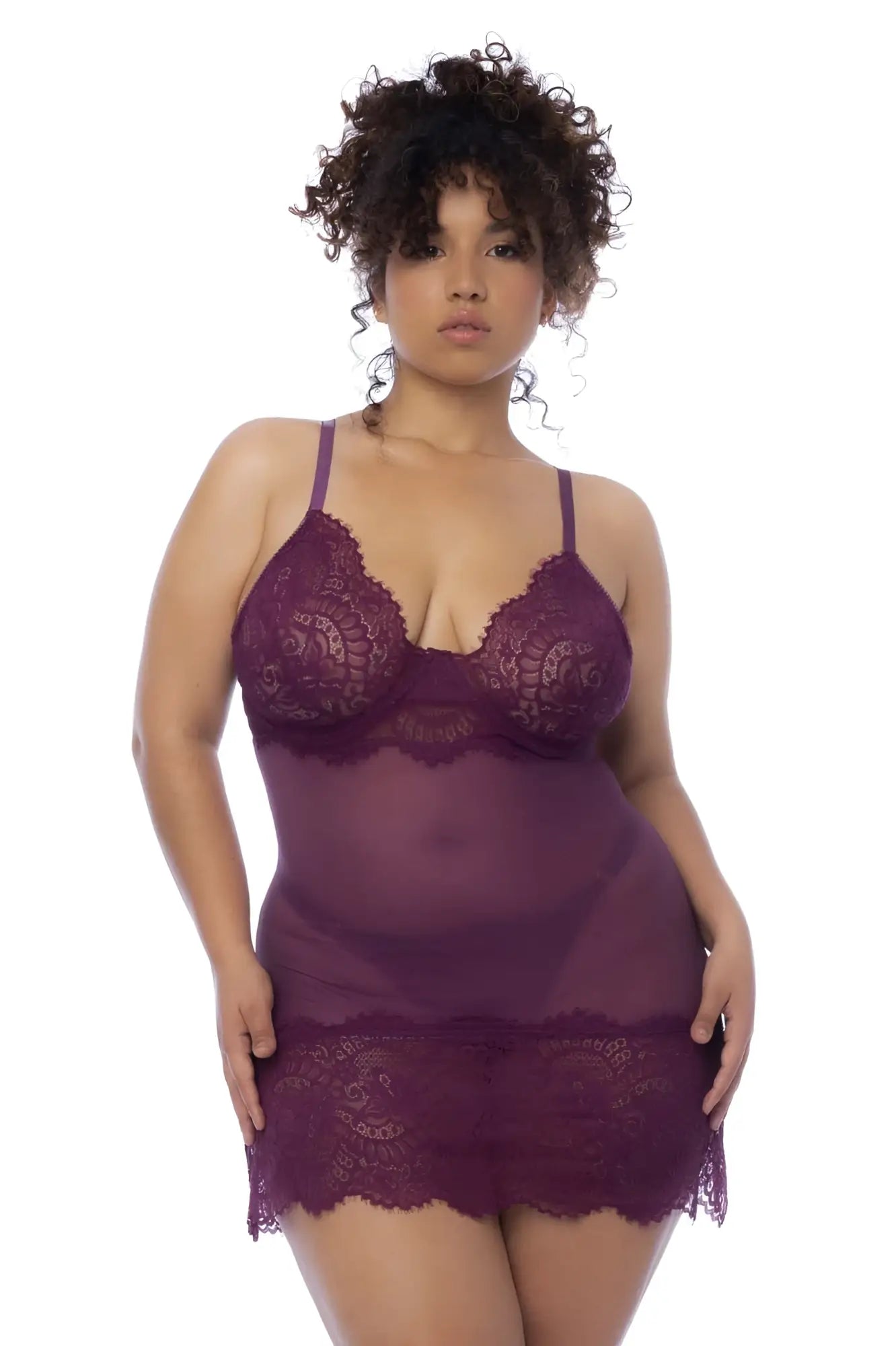 A plus-size woman wears a sheer purple lace Mapale 7554X babydoll with intricate floral patterns and delicate straps
