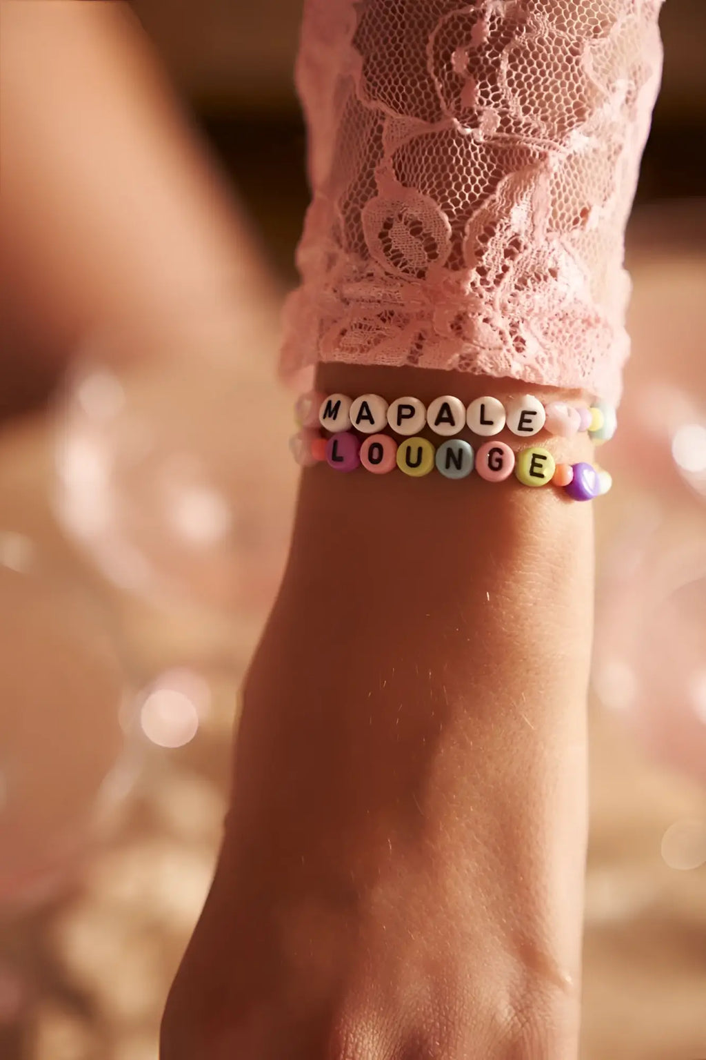 A colorful beaded bracelet with alphabet beads spelling mapale lounge worn on wrist with mapale 7599 sleep romper rose