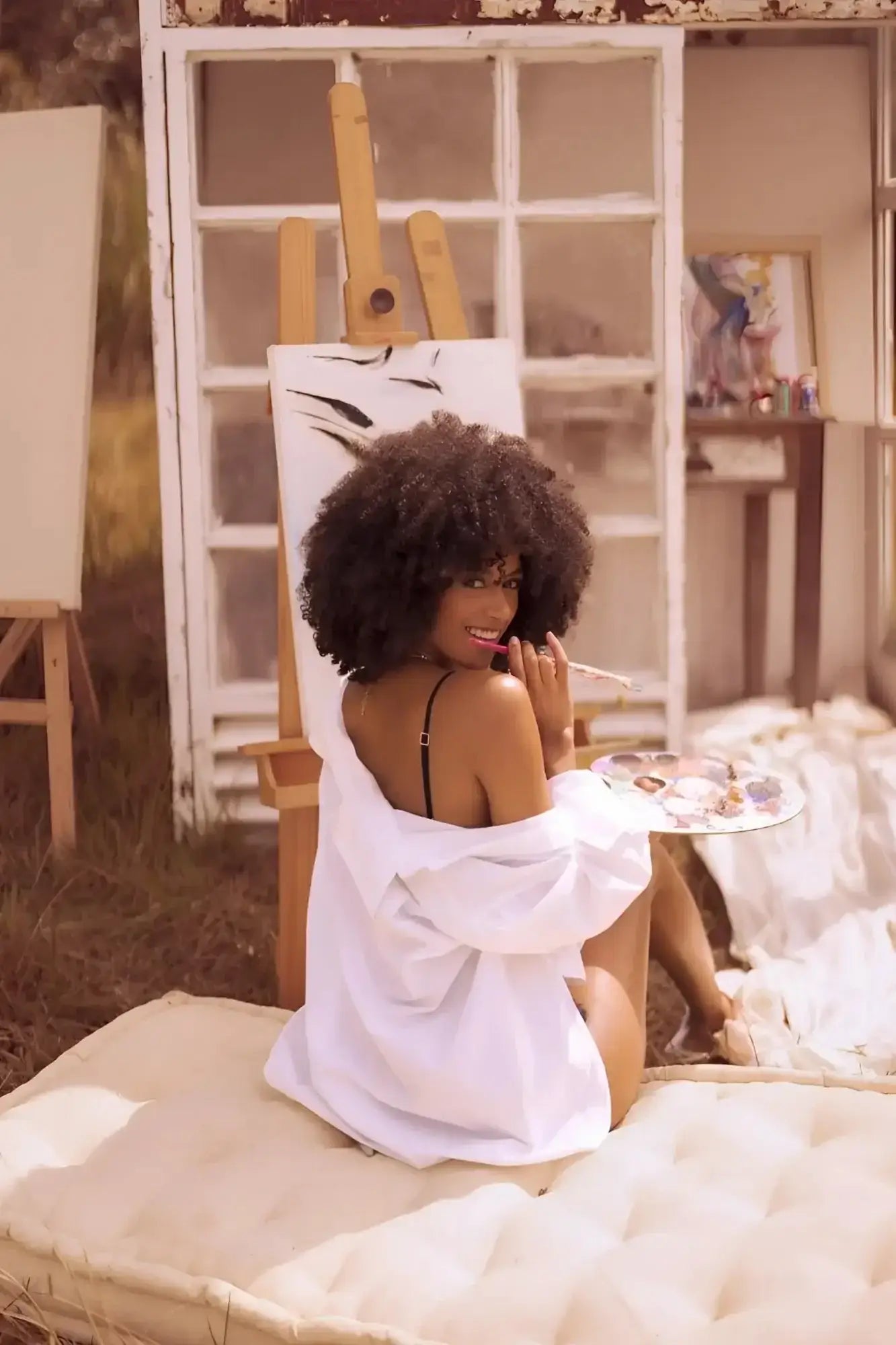 A woman wearing mapale 8864 two piece set color night butterfly oversized white shirt over black lingerie sits on white