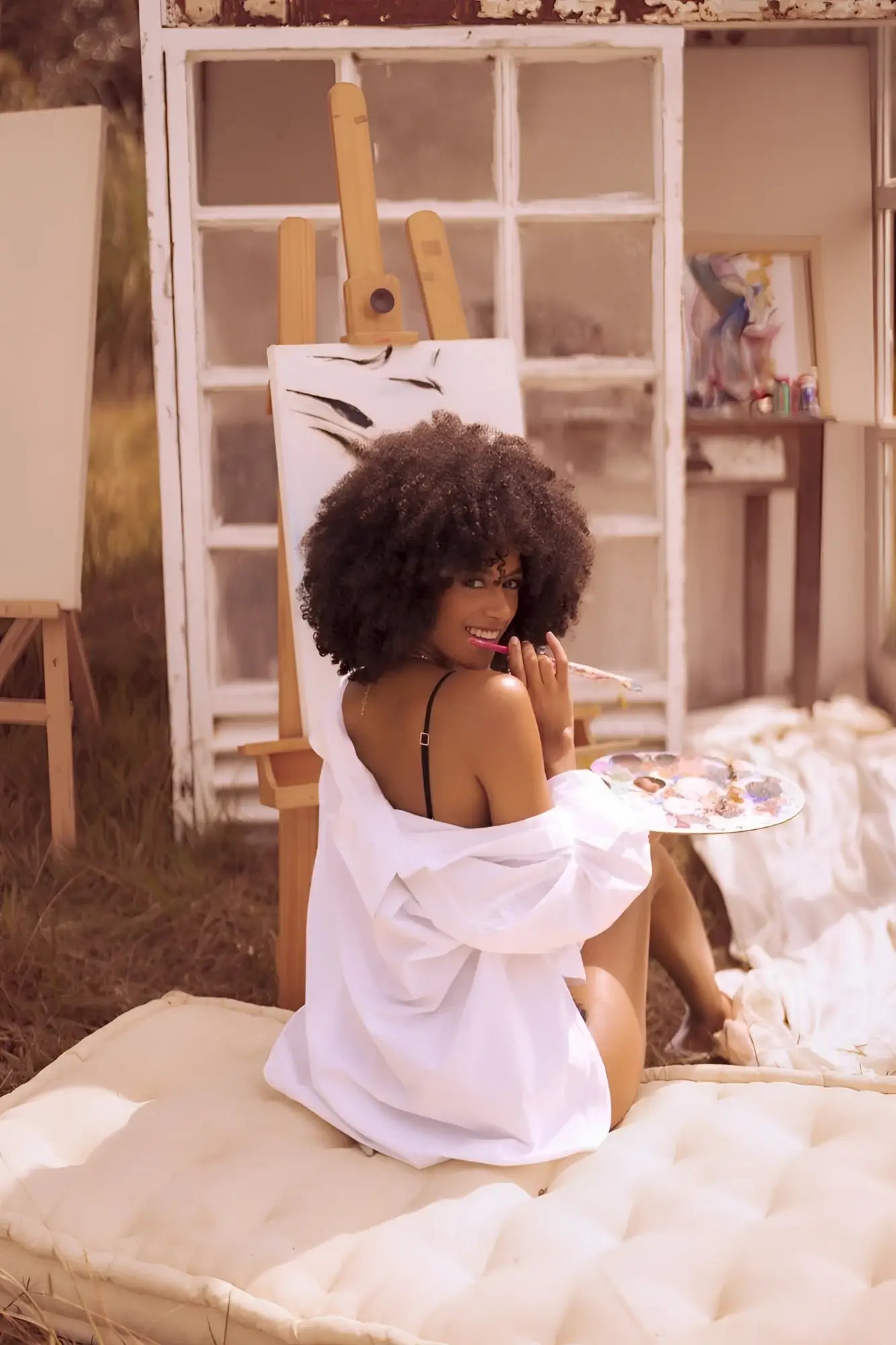 A woman wearing mapale 8864 two piece set color night butterfly oversized white shirt over black lingerie sits on white cushion
