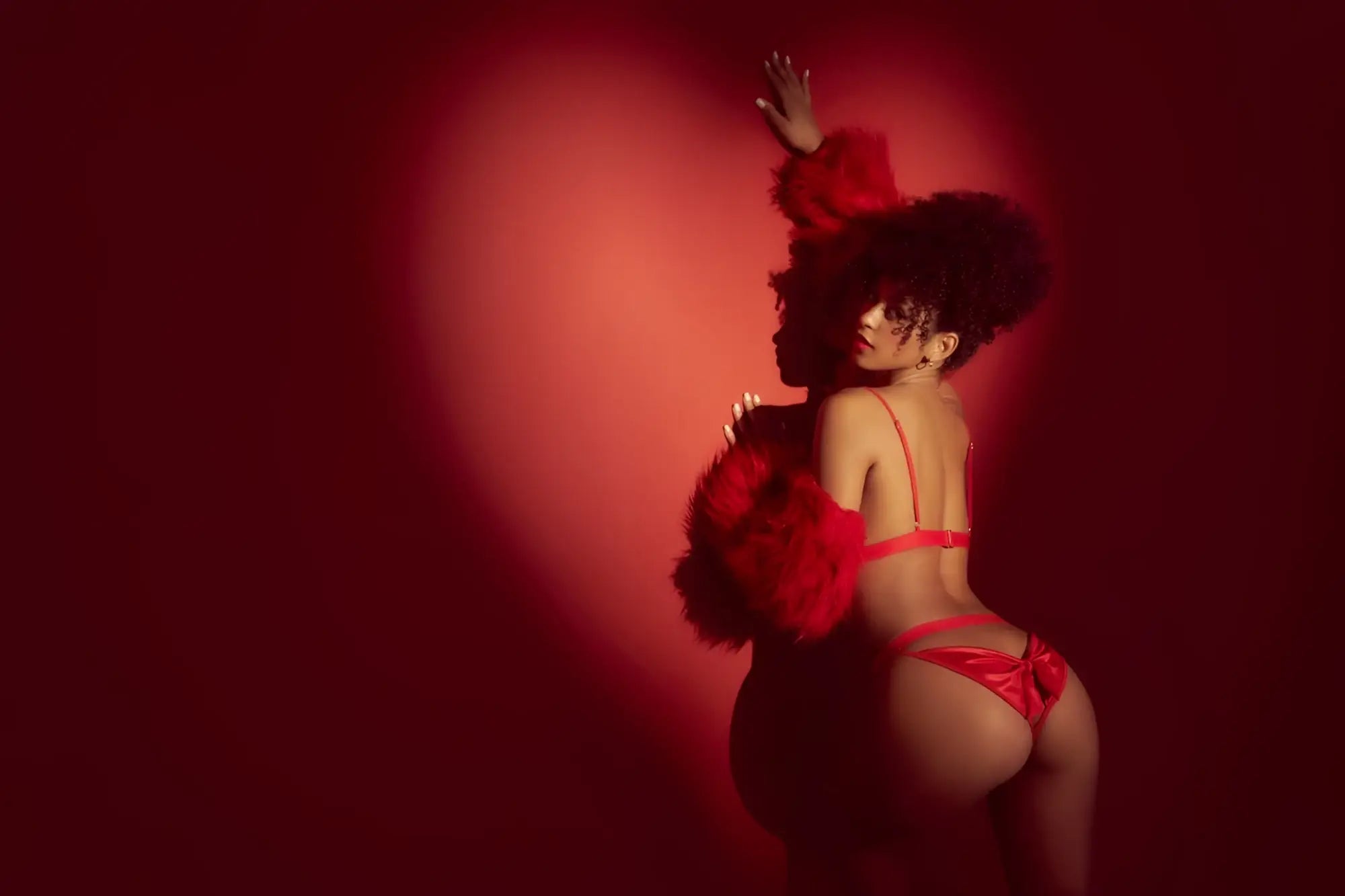 A woman wearing mapale 8901 two piece set in red shiny satin lingerie with matching feathered shoulder accents