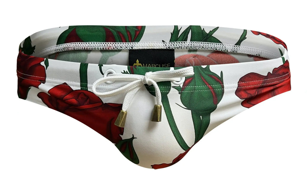 White swim trunks with red rose and green stem print featuring gold-tone hardware drawstring ties by marcuse amour