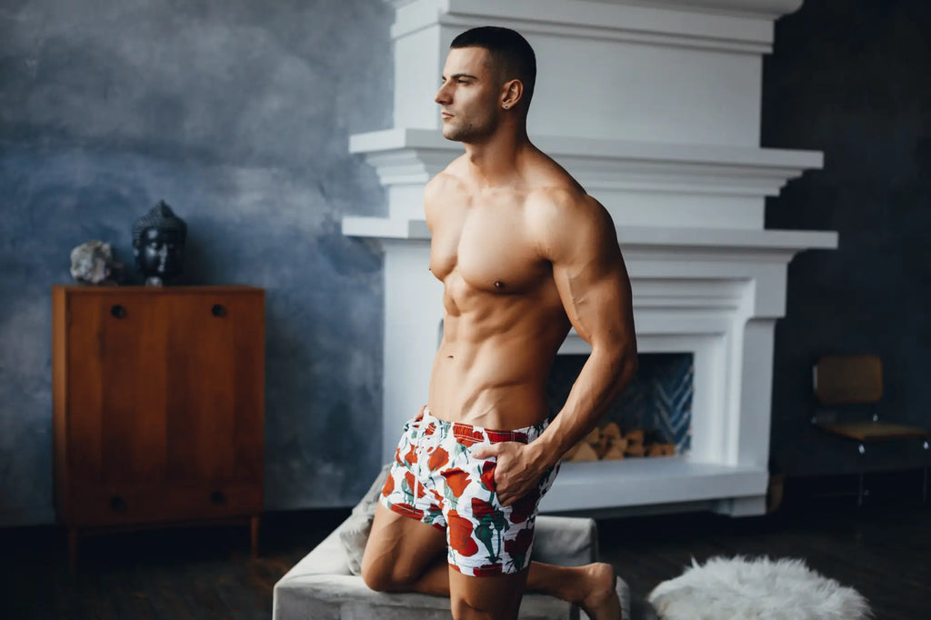 Man wearing red and white floral patterned marcuse amour shorts showing the back side of the boxer shorts