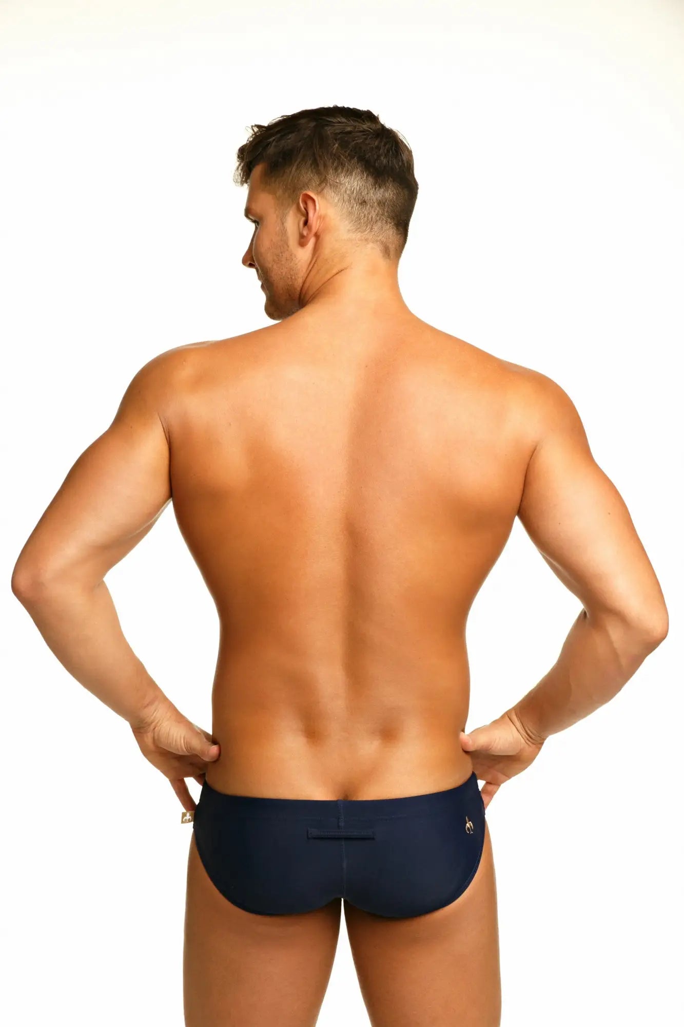 Navy blue Marcuse Arrest Me bikini swimwear briefs with a small gold logo on the back waistband shown from behind