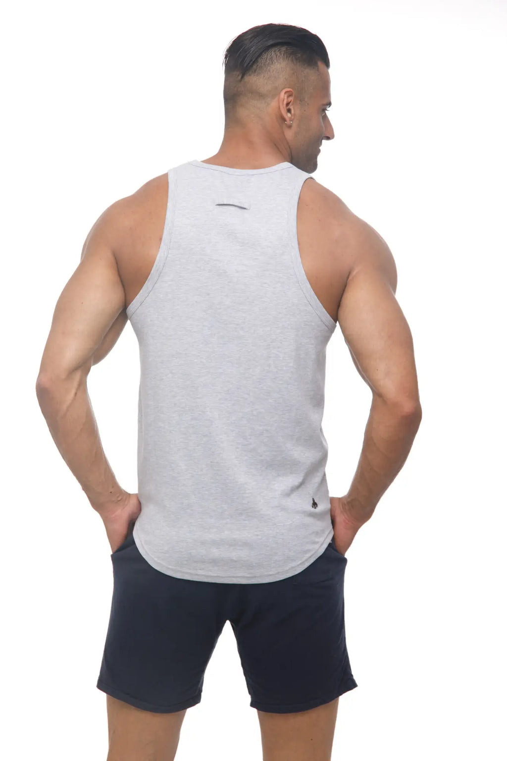 Back view of a heather gray marcuse avalon sleeveless athletic tank top with black logo and small emblem on hem