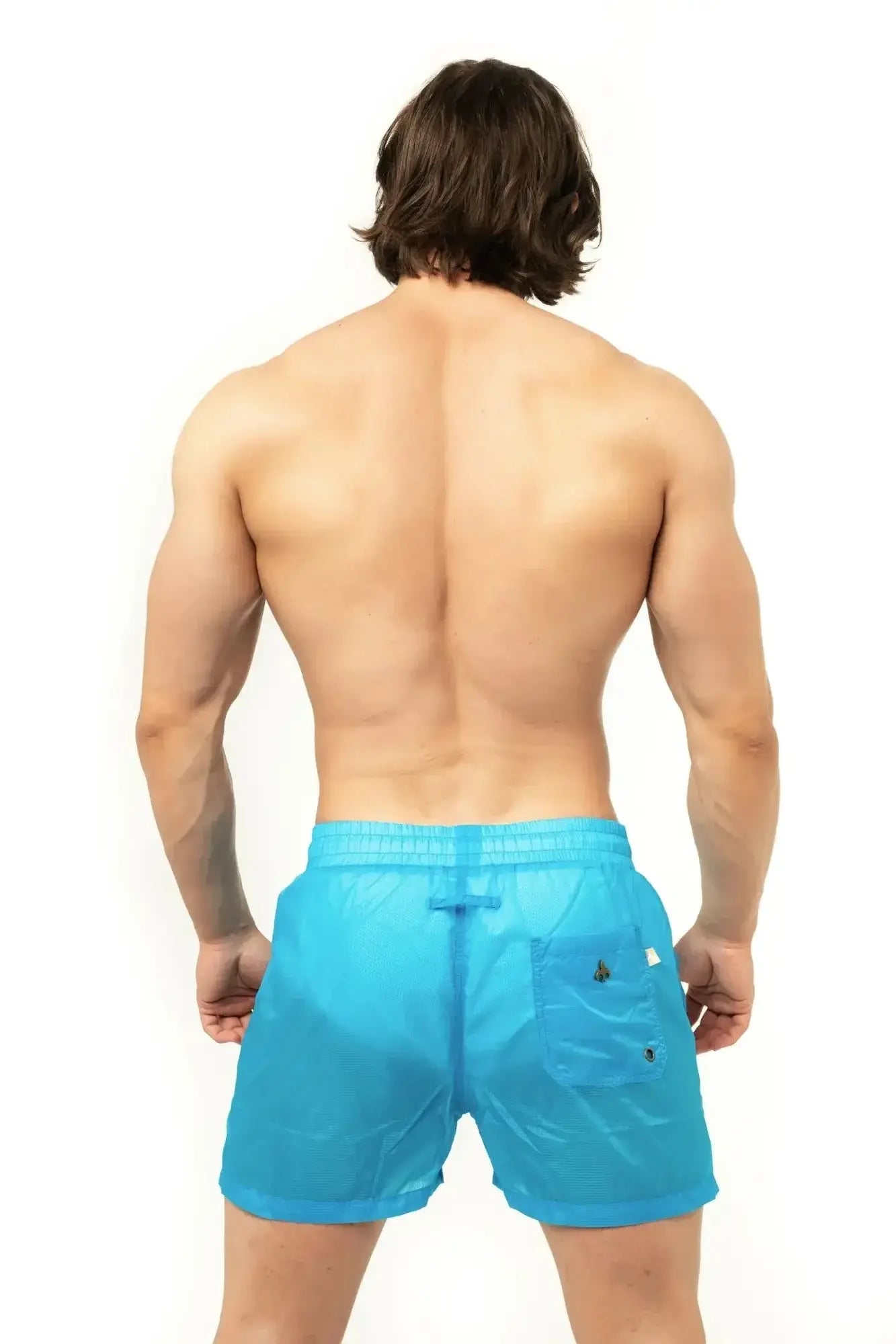 Marcuse Babylon shorts are bright blue lightweight swim trunks with subtle textured weave and black button accents on pocket