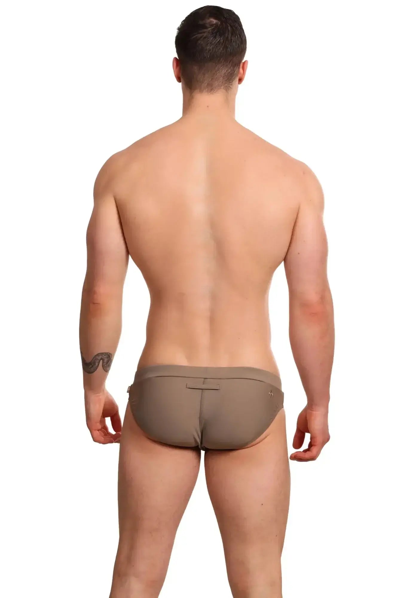 Tan form-fitting marcuse burleigh bikini swim trunks with a subtle back closure detail for swimwear use