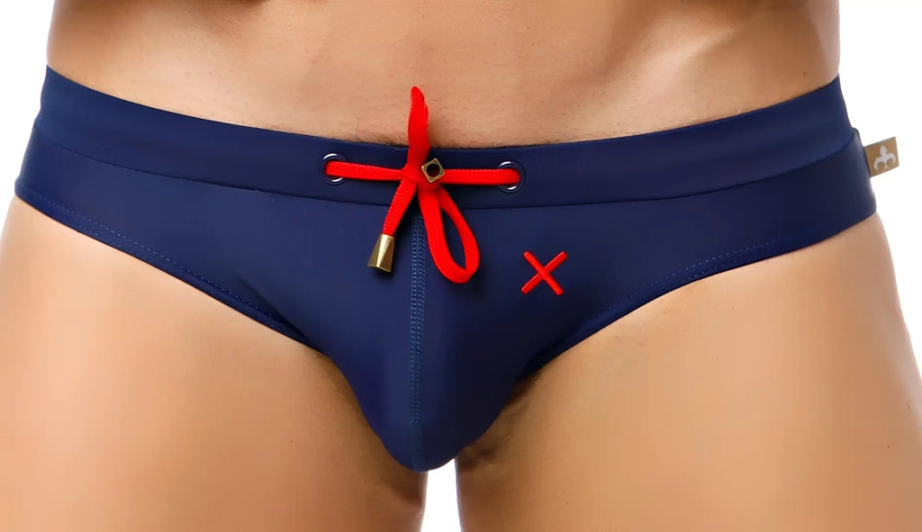 Marcuse Burleigh bikini navy blue swim trunks with red drawstring and embroidered x for stylish swimwear use