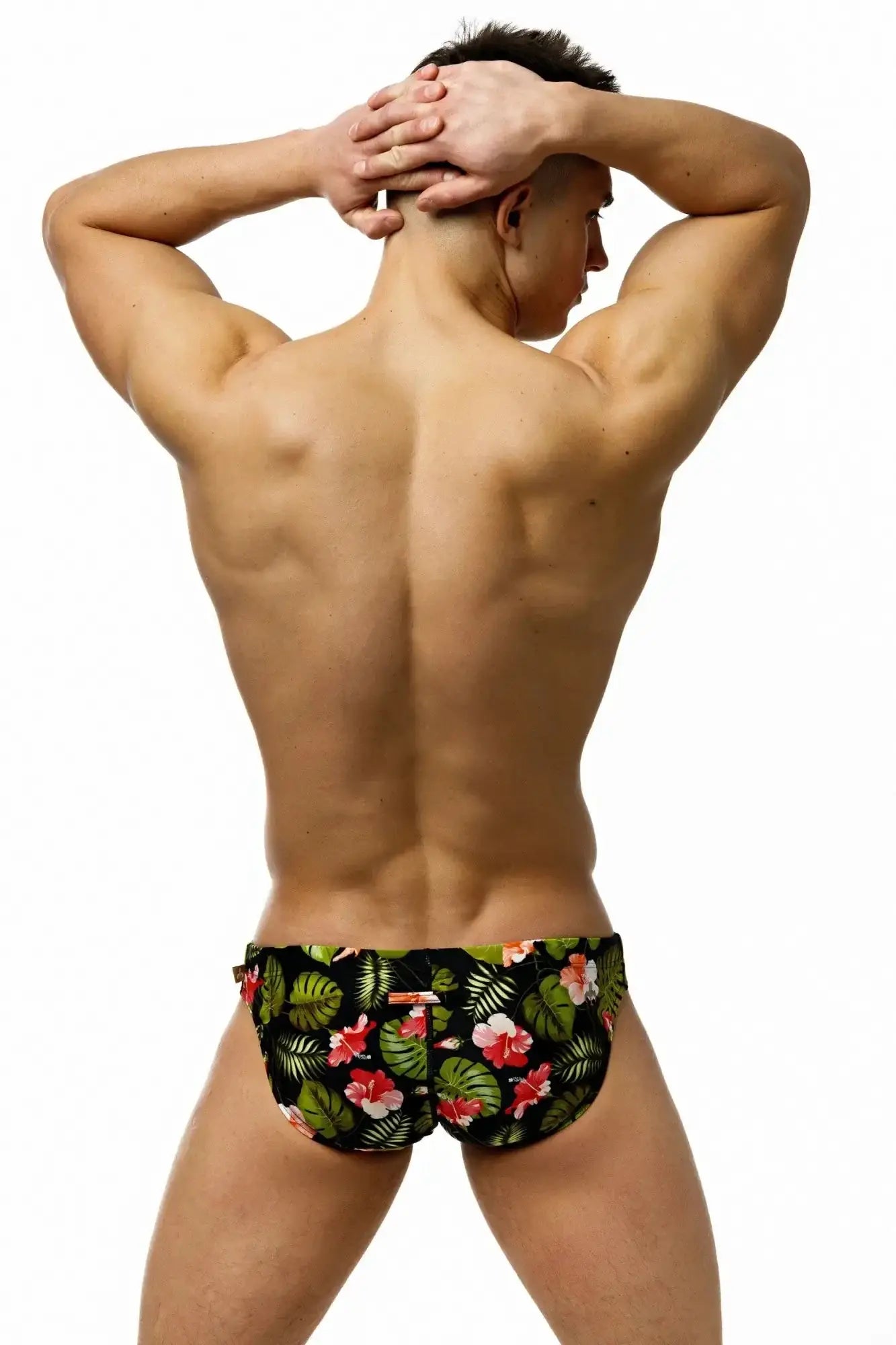 Marcuse Forrest brief swimwear black trunks with vibrant tropical pink hibiscus floral pattern and green leaves