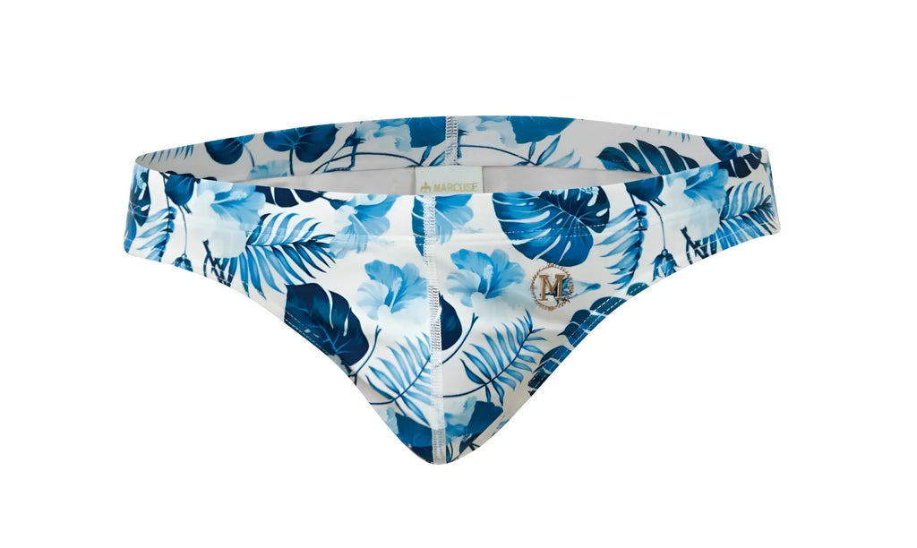 Marcuse Forrest brief swimwear featuring blue and white tropical leaf-patterned men’s swim trunks with metallic logo