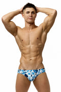Marcuse Forrest brief swimwear featuring blue and white tropical leaf-patterned trunks for casual beachwear