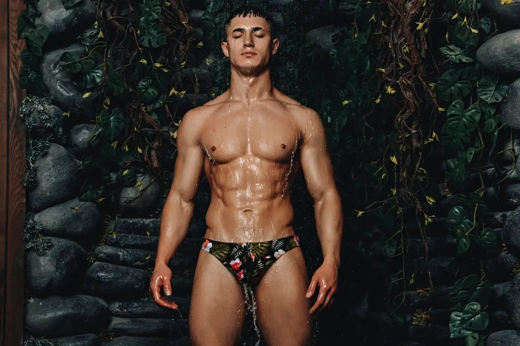 Marcuse Forrest thong swimwear featuring vibrant red and green tropical floral pattern on dark fabric