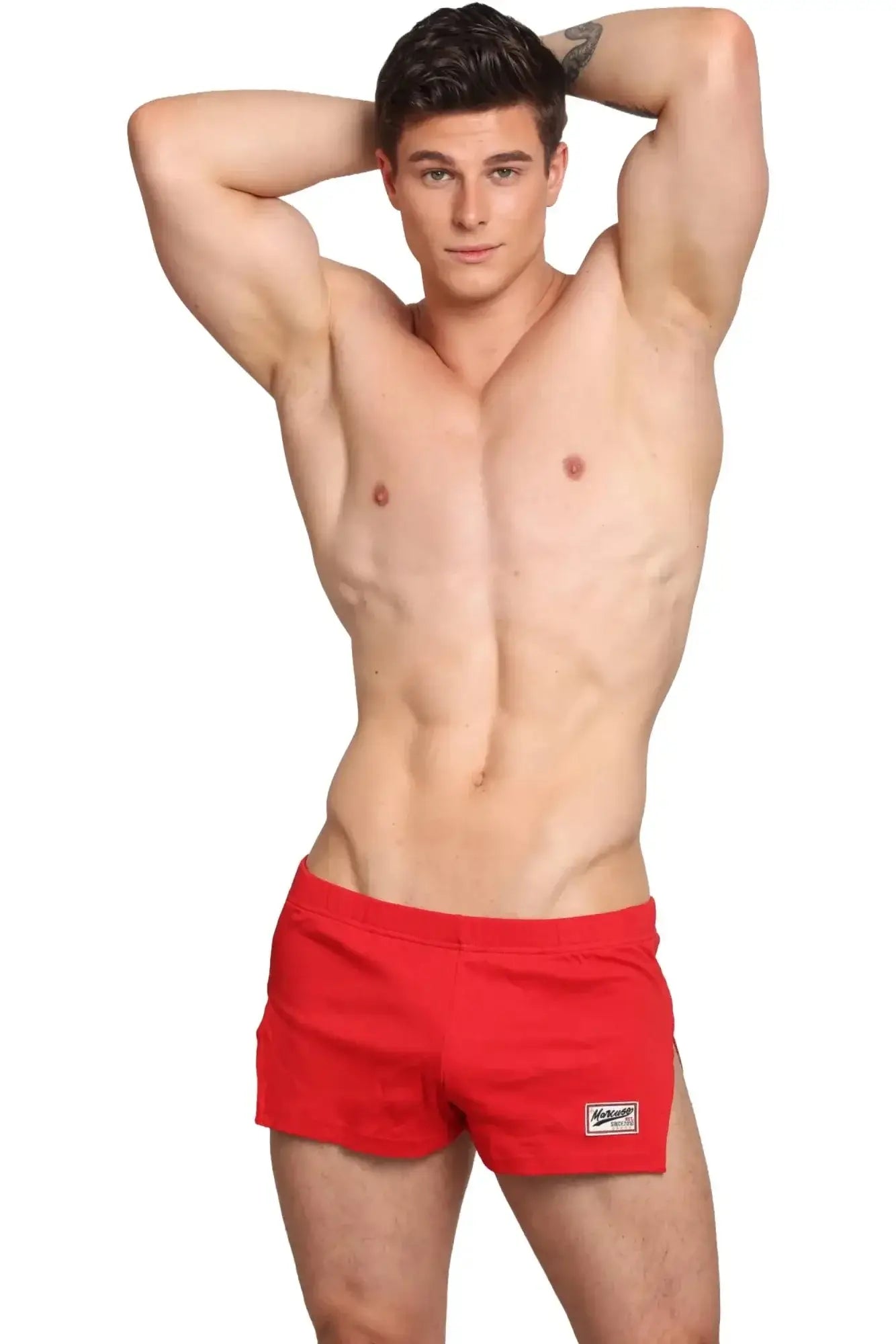 Red Marcuse Hansar athletic shorts with a small white logo patch on the lower right leg for active wear