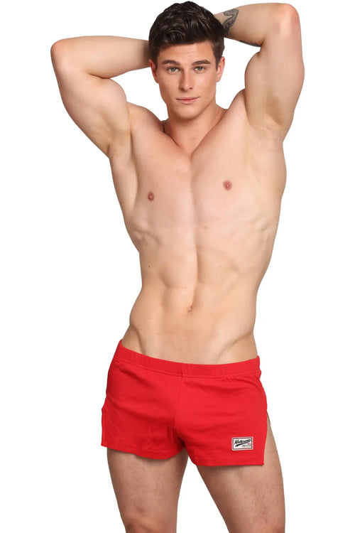 Red Marcuse Hansar athletic shorts with a small white logo patch on the lower right leg for active wear