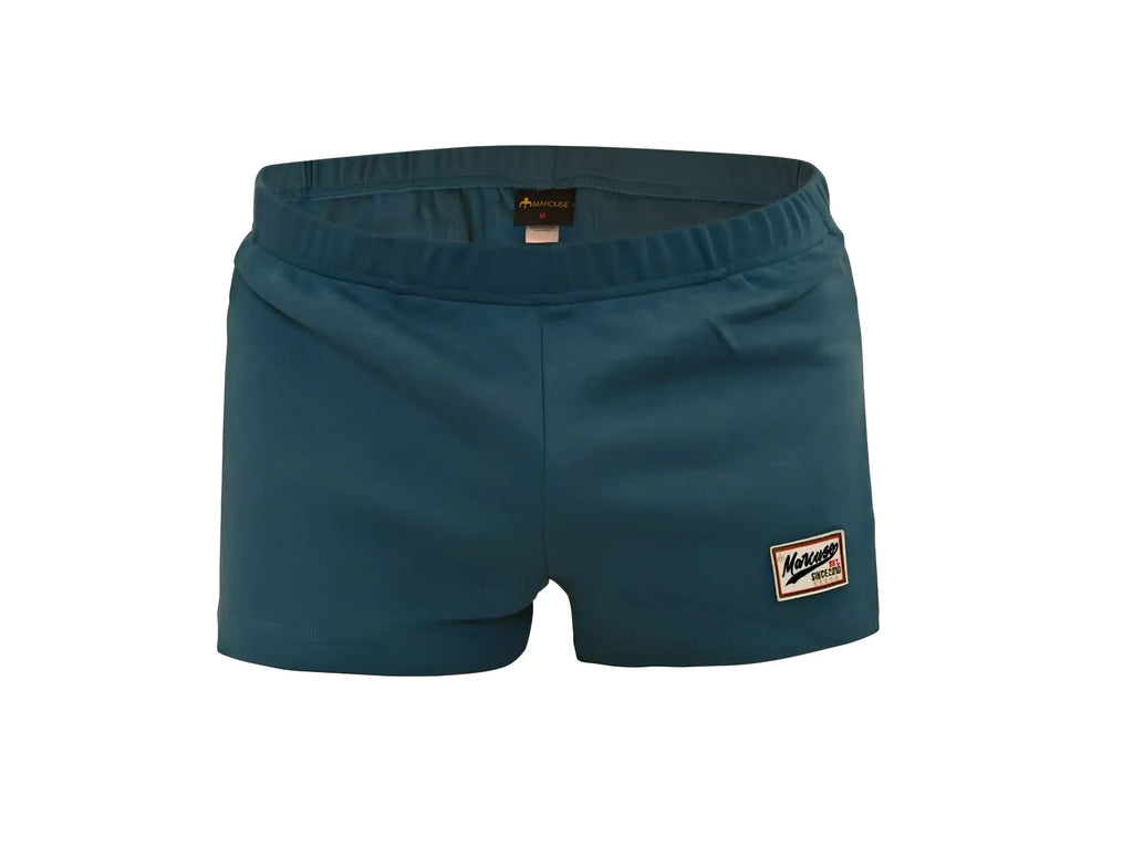 Marcuse Hansar shorts in teal with elastic waist and rectangular patch logo on the lower right leg