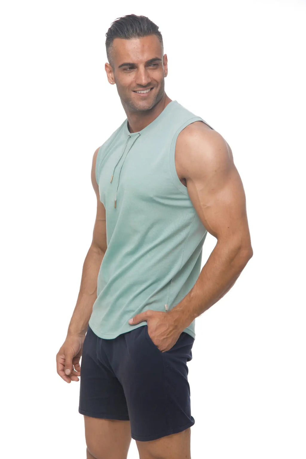 A man wearing a light green marcuse hero tank top with sleeveless hoodie and drawstring neckline