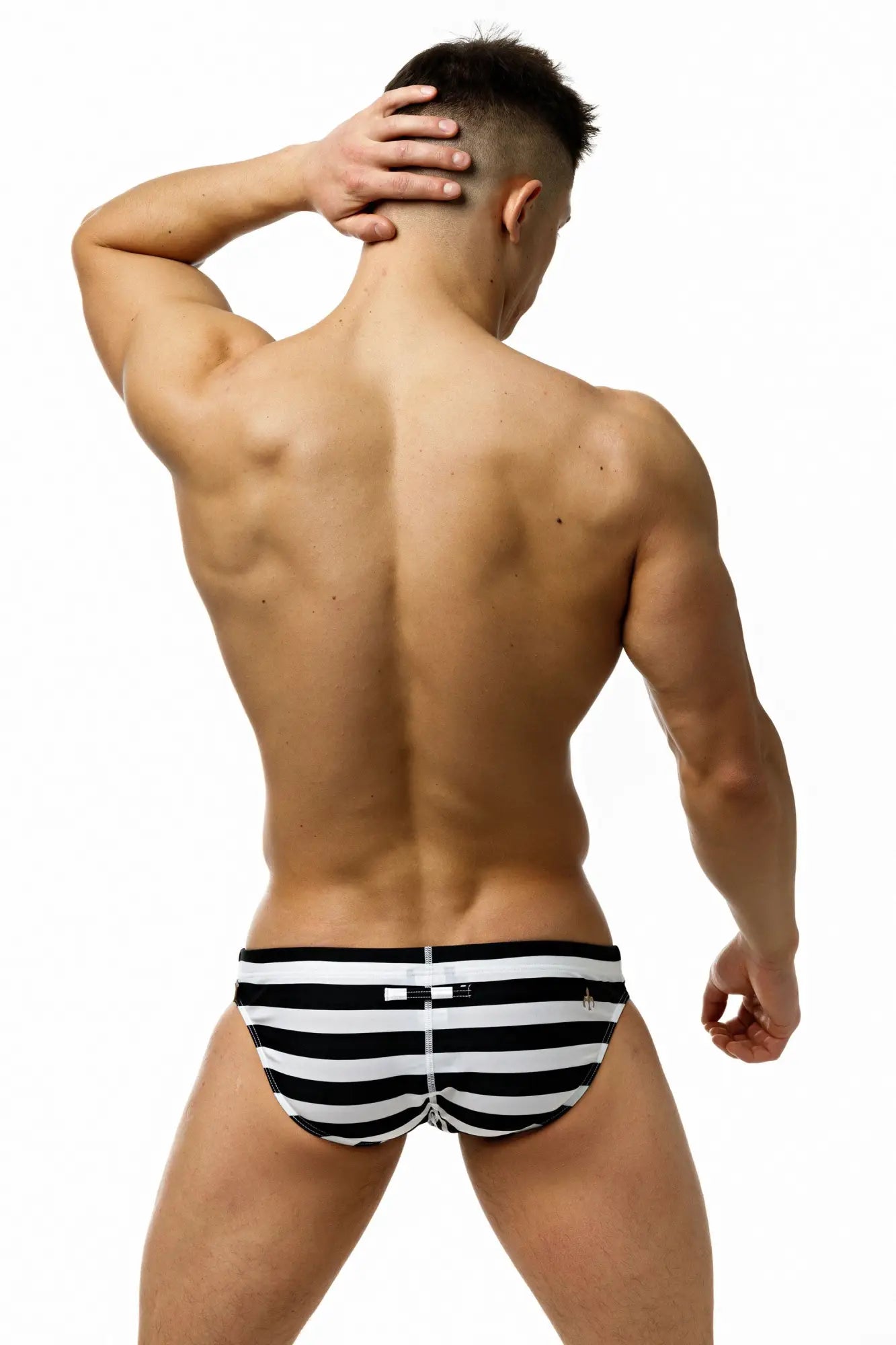 Marcuse Journée brief swimwear featuring black and white striped swim trunks with a small waistband logo