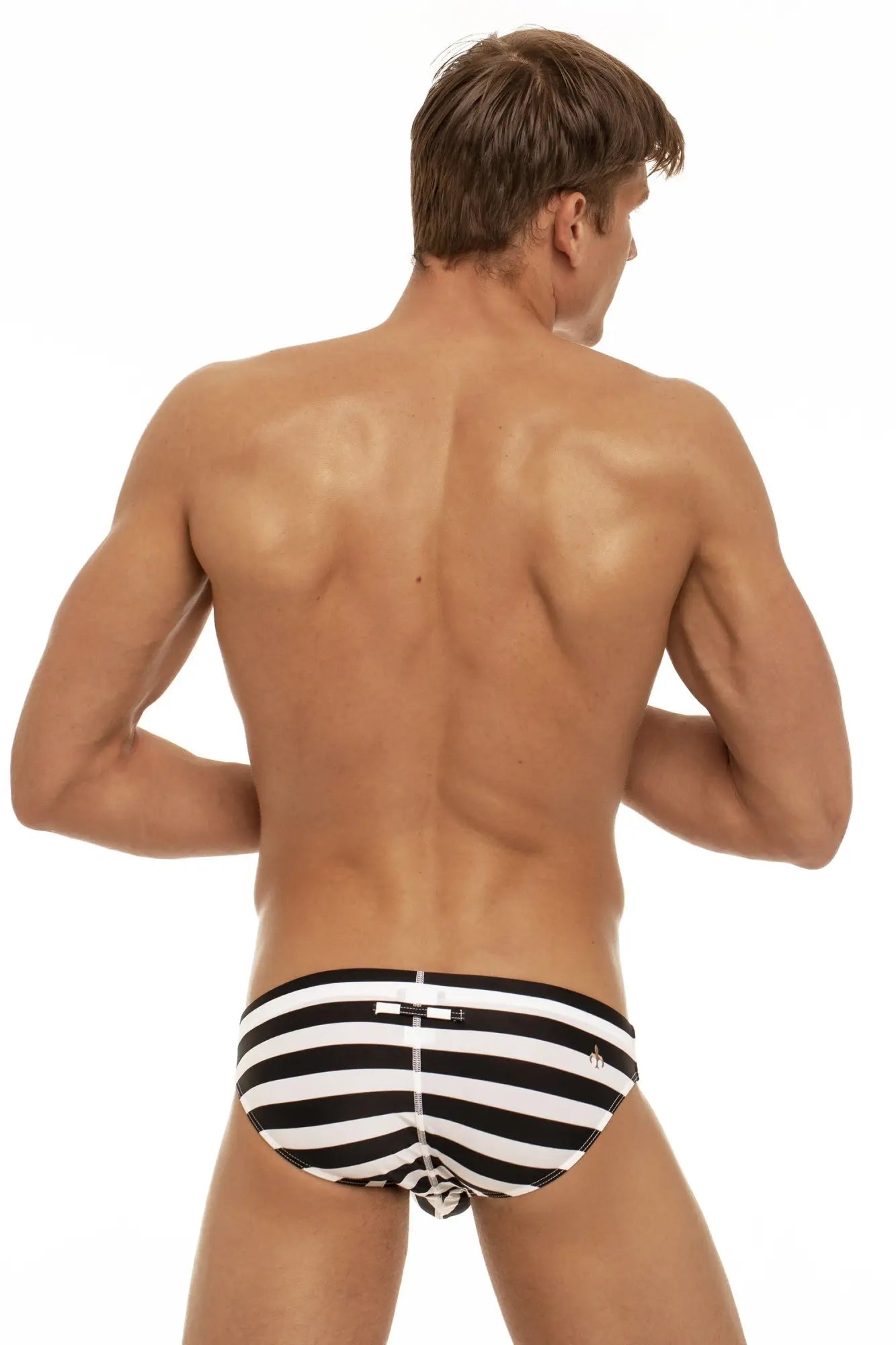 Back view of marcuse journée brief swimwear black and white striped swim trunks with a small logo on the back