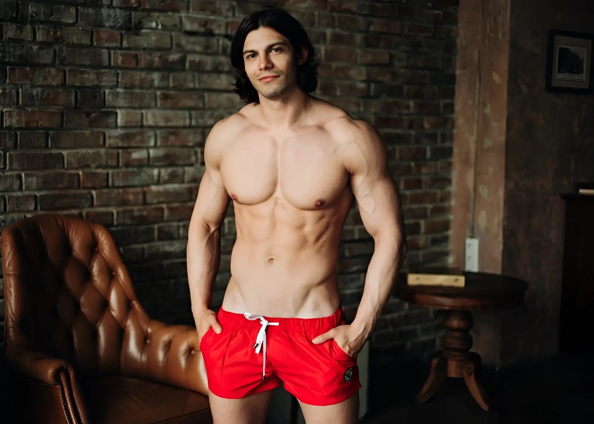 A man wearing bright red Marcuse League shorts with a white drawstring and small logo on the left leg