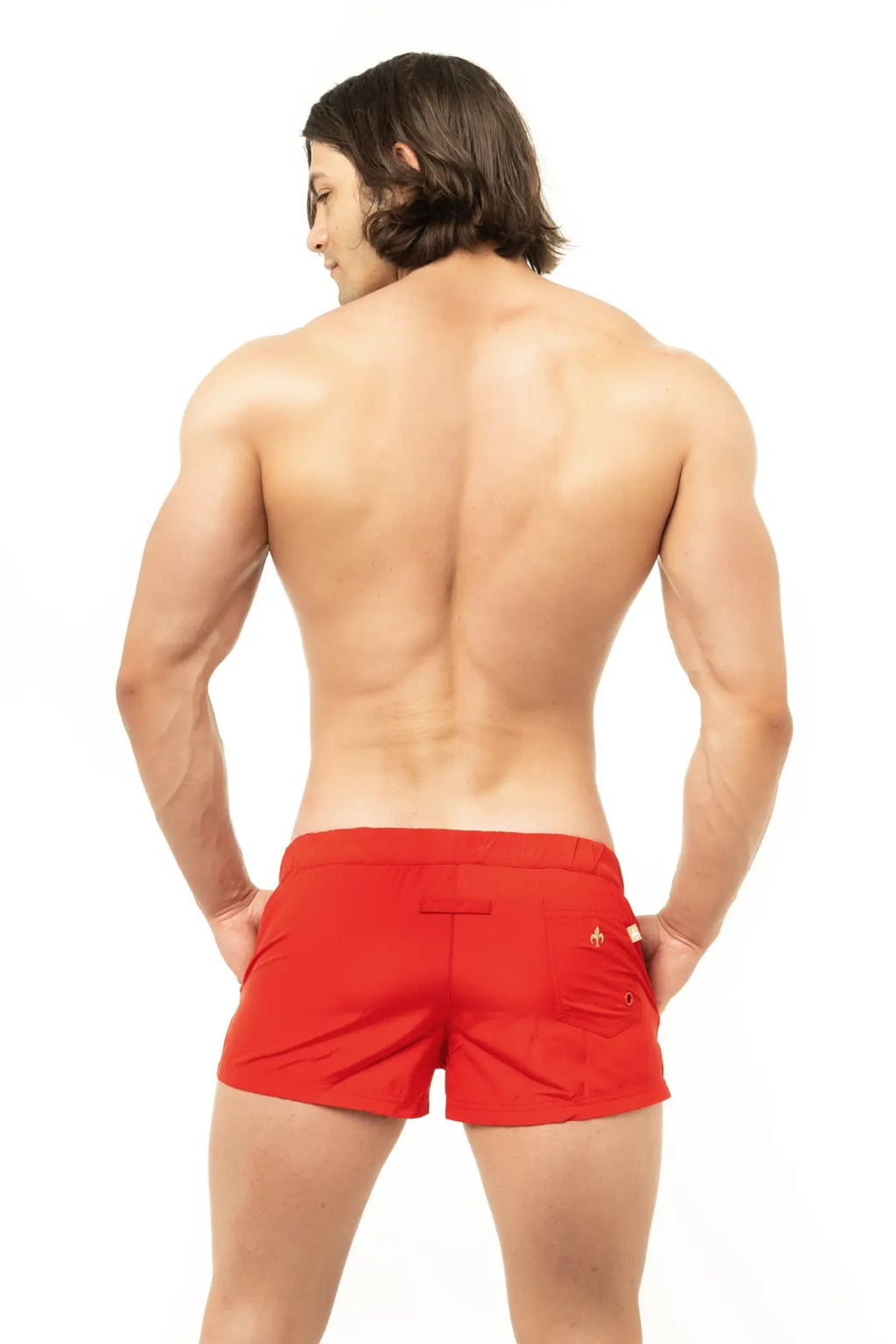 Red marcuse league athletic shorts made of breathable fabric showing small gold logo on the back pocket