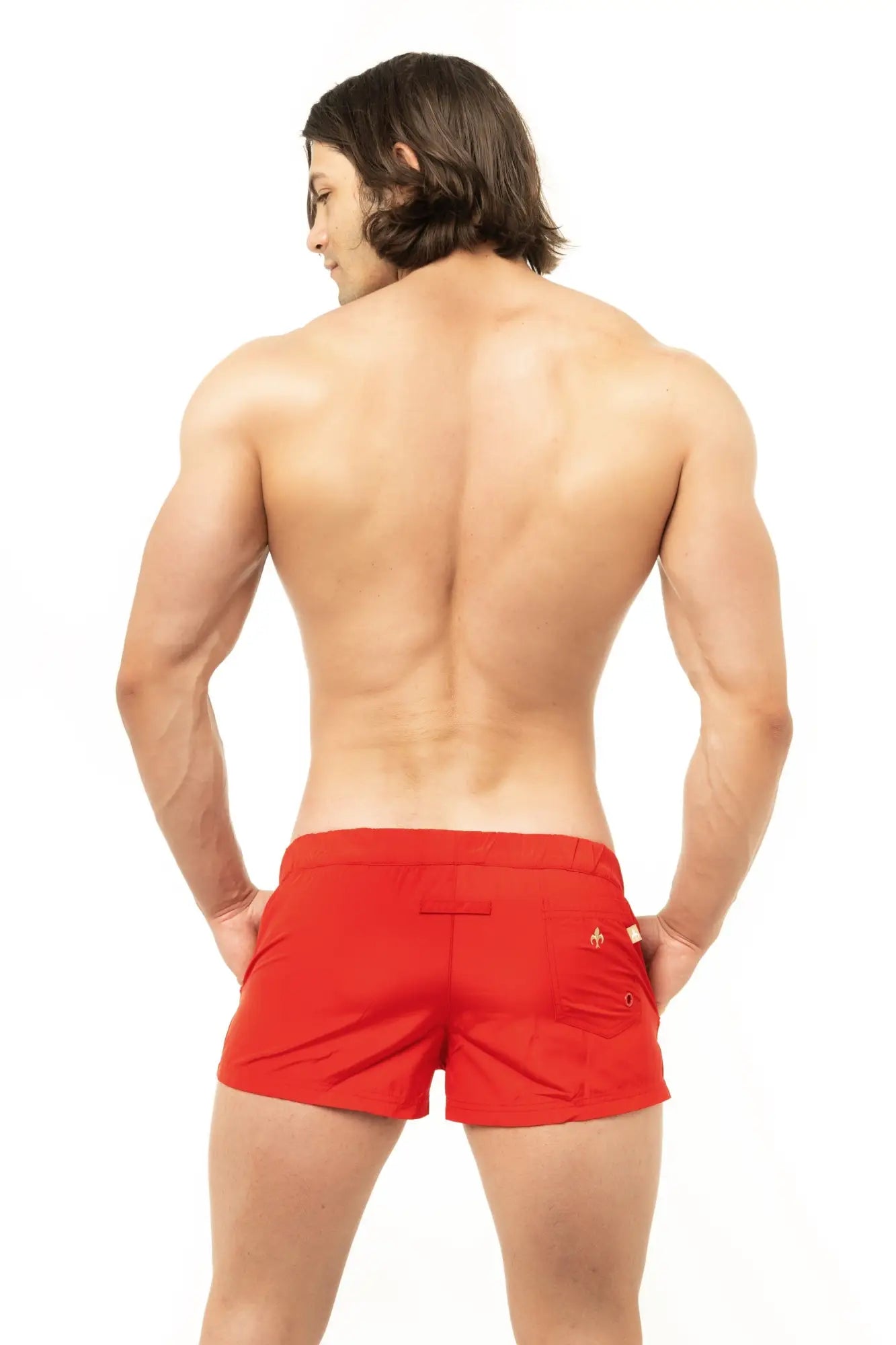 Red marcuse league athletic shorts made of breathable fabric showing small gold logo on the back pocket