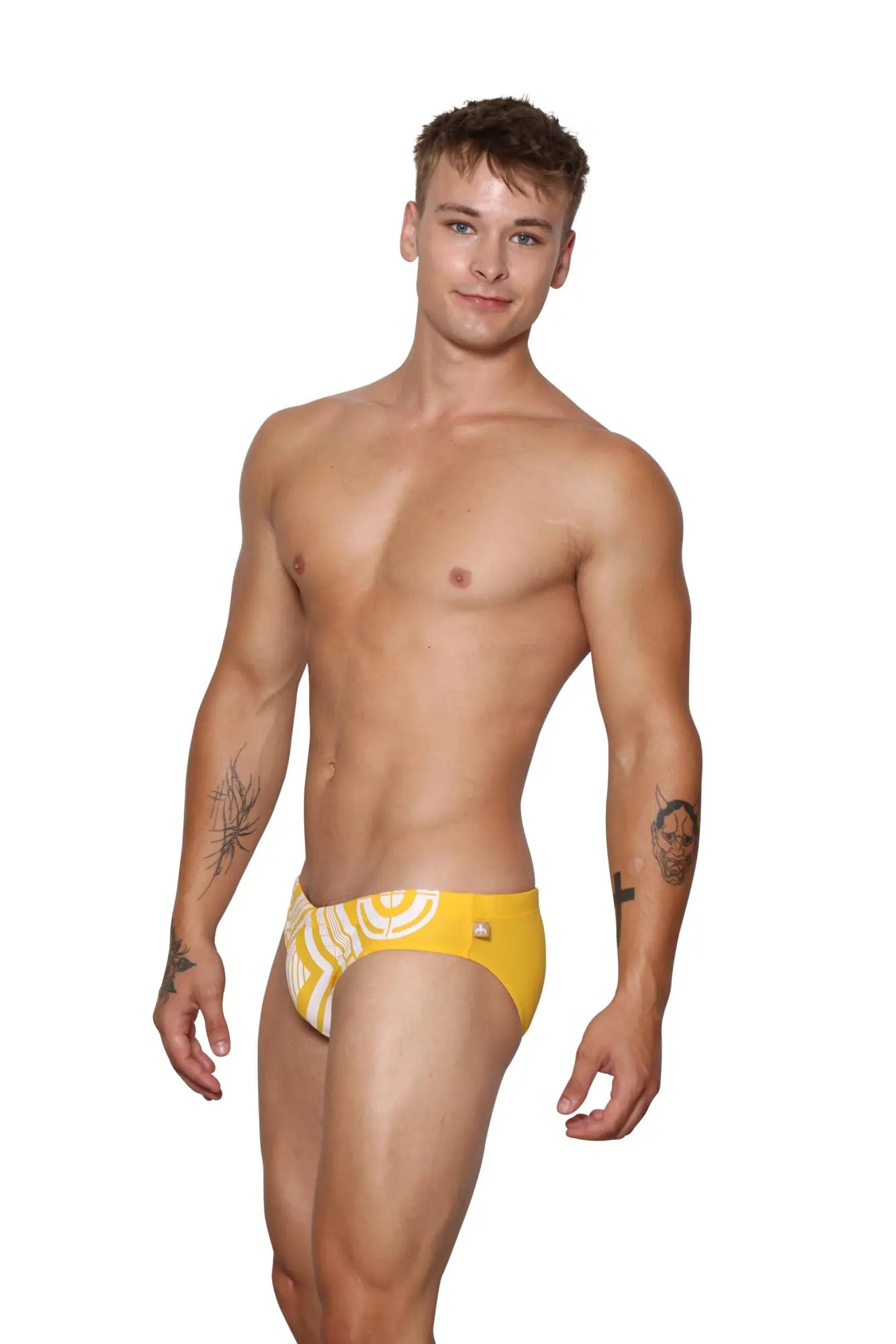 Bright yellow Marcuse Mecha bikini swimwear swim trunks with white swirling pattern and small gold side logo