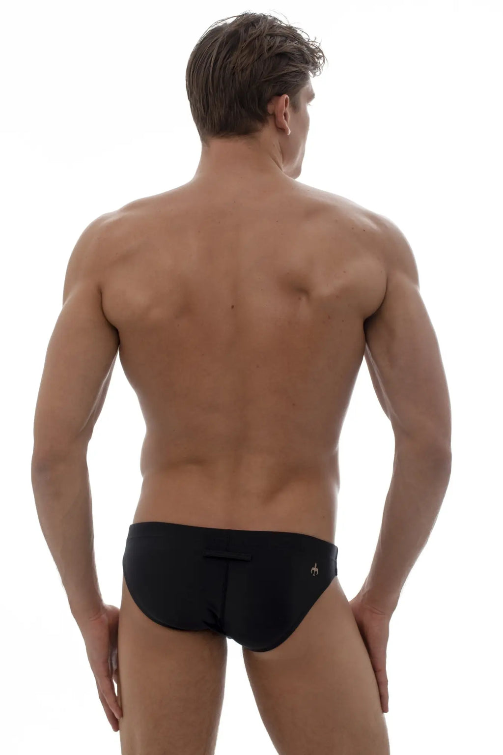 Black brief style swim trunks with small gold marcuse logo on left hip from marcuse oasis bikini swimwear collection