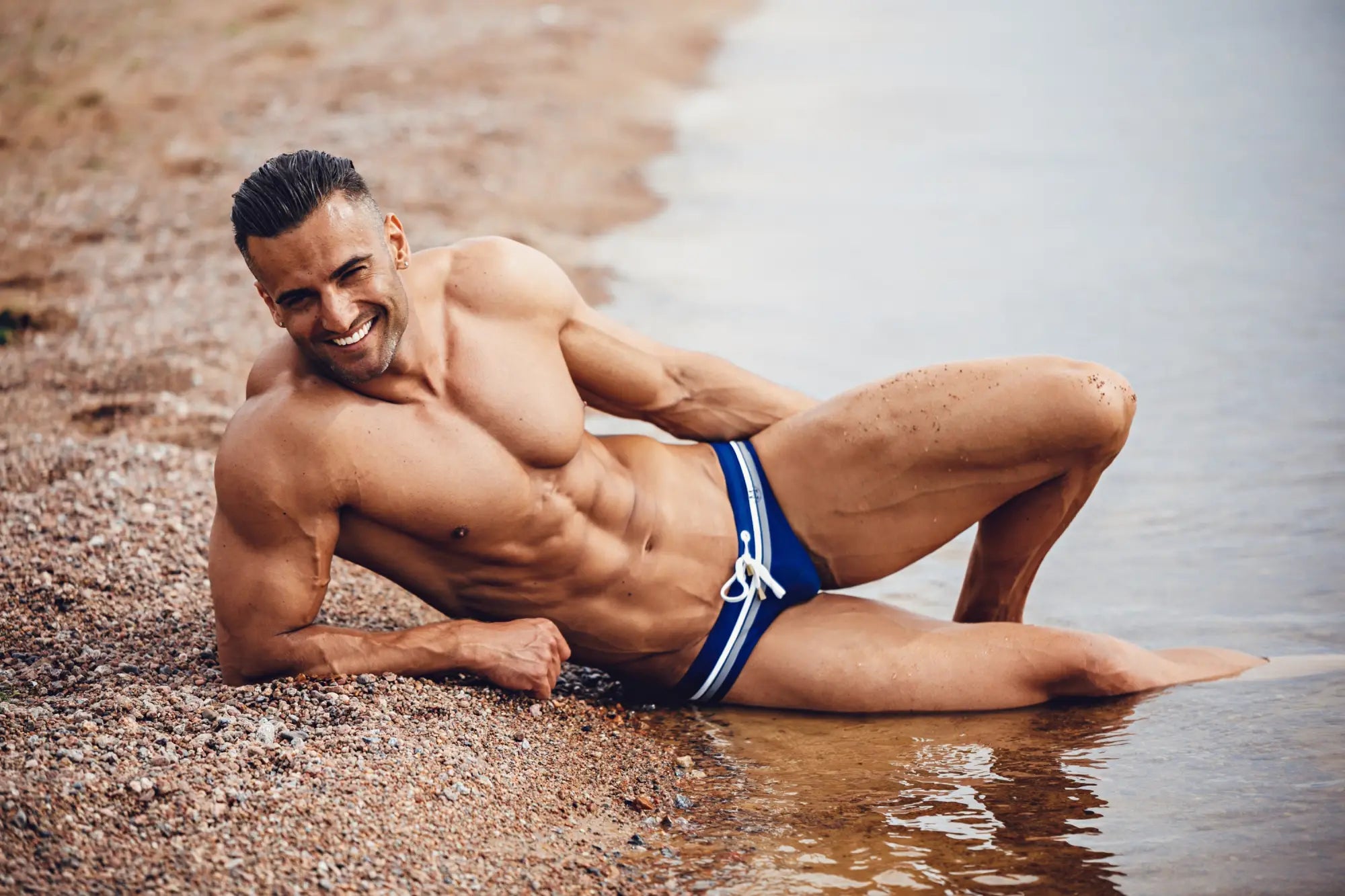 Blue swim trunks with white stripes and drawstring waistband from marcuse ocean bikini swimwear collection