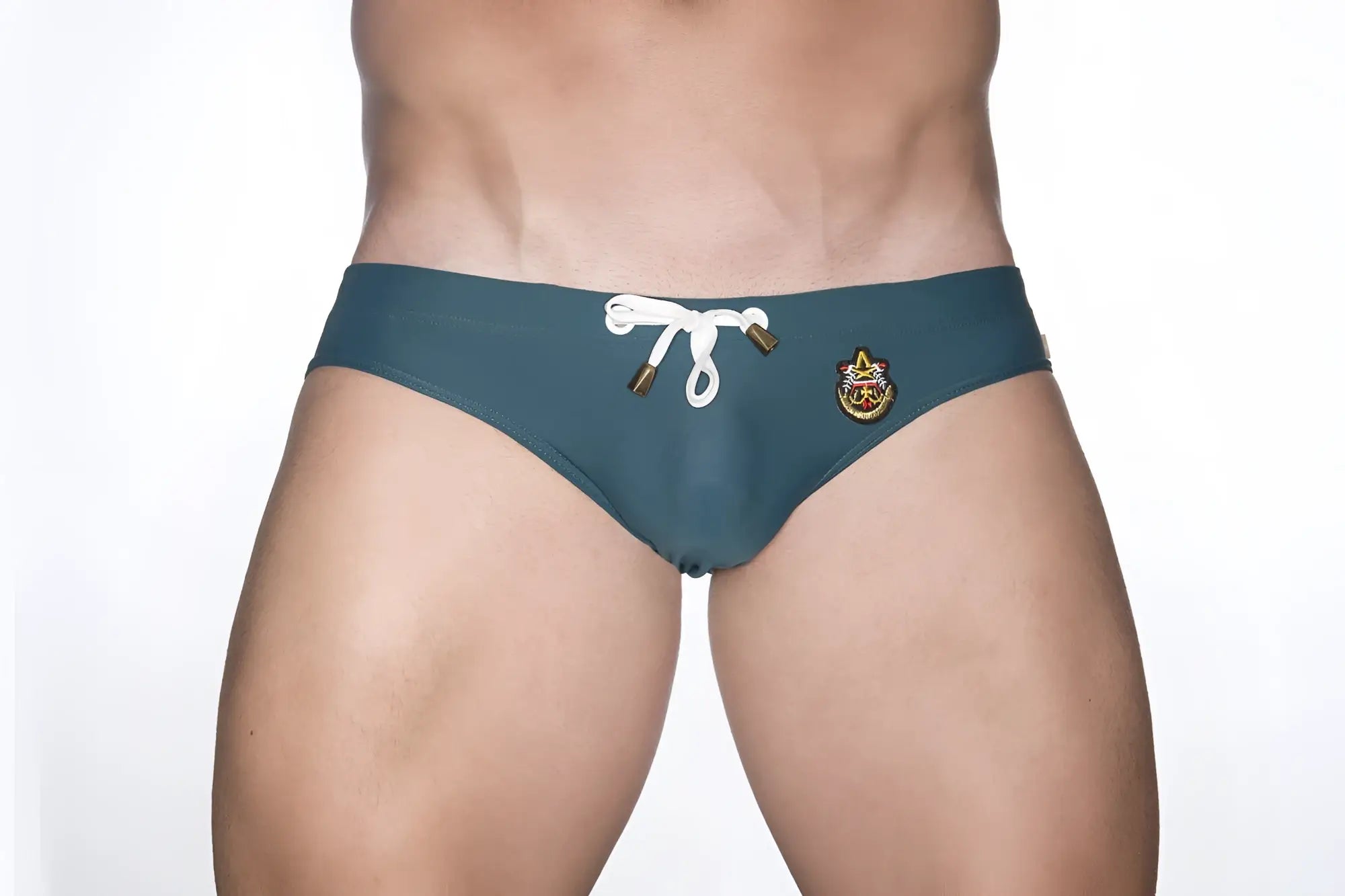 Marcuse patrol bikini swimwear teal swim trunks with white drawstring gold hardware and embroidered crest on side