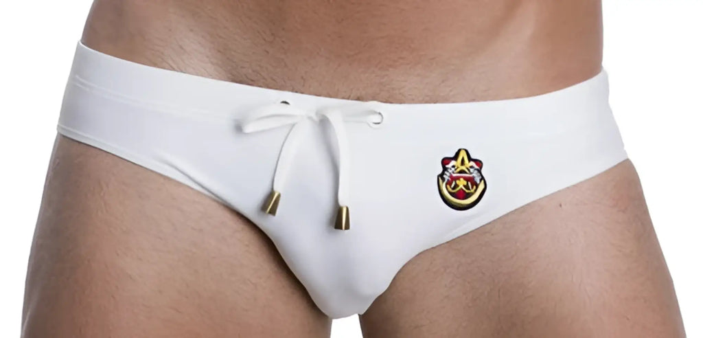White men’s marcuse patrol bikini swimwear trunks with gold drawstring and front embroidered logo