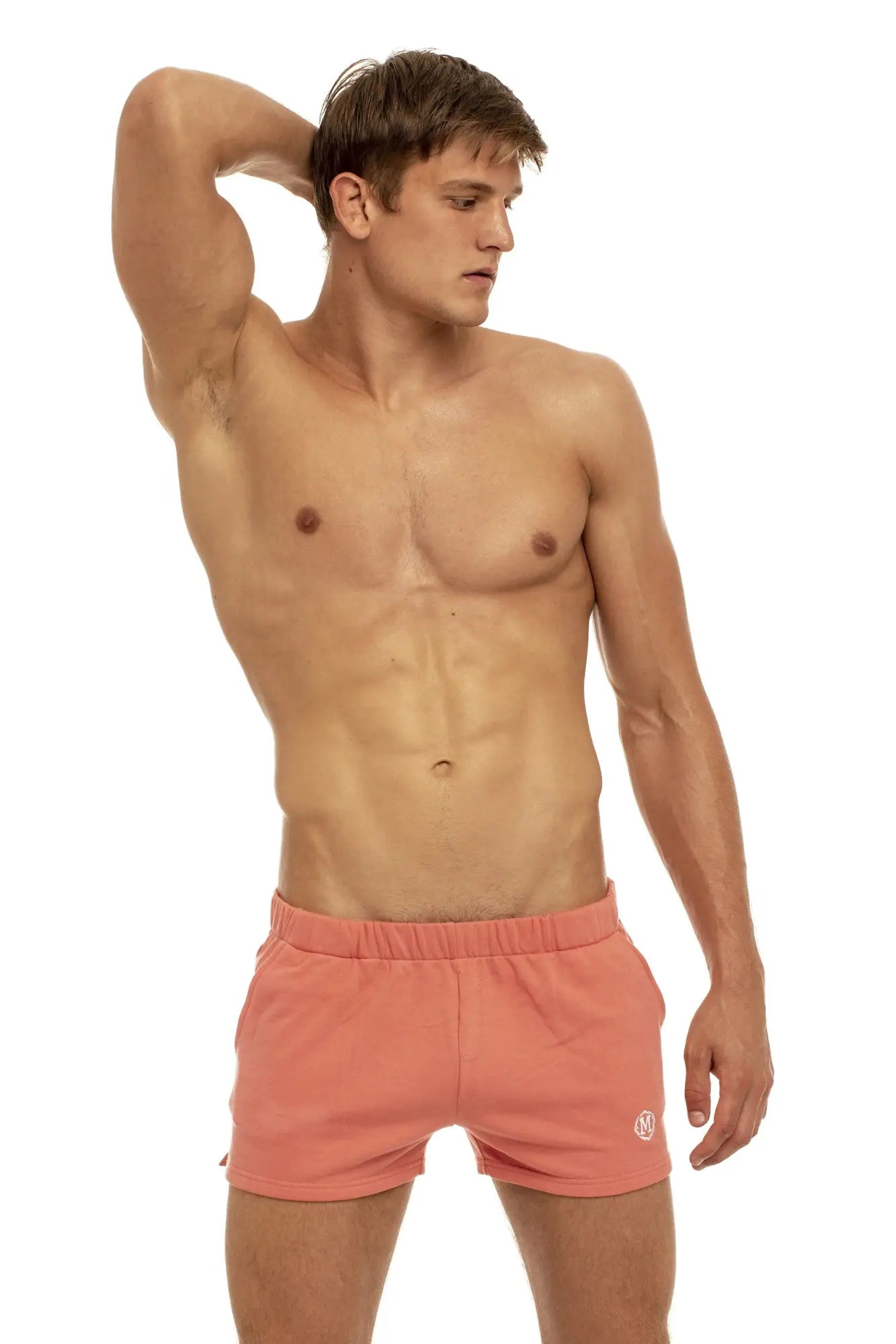 Coral-colored marcuse physical shorts with drawstring waistband and small embroidered logo on lower right leg