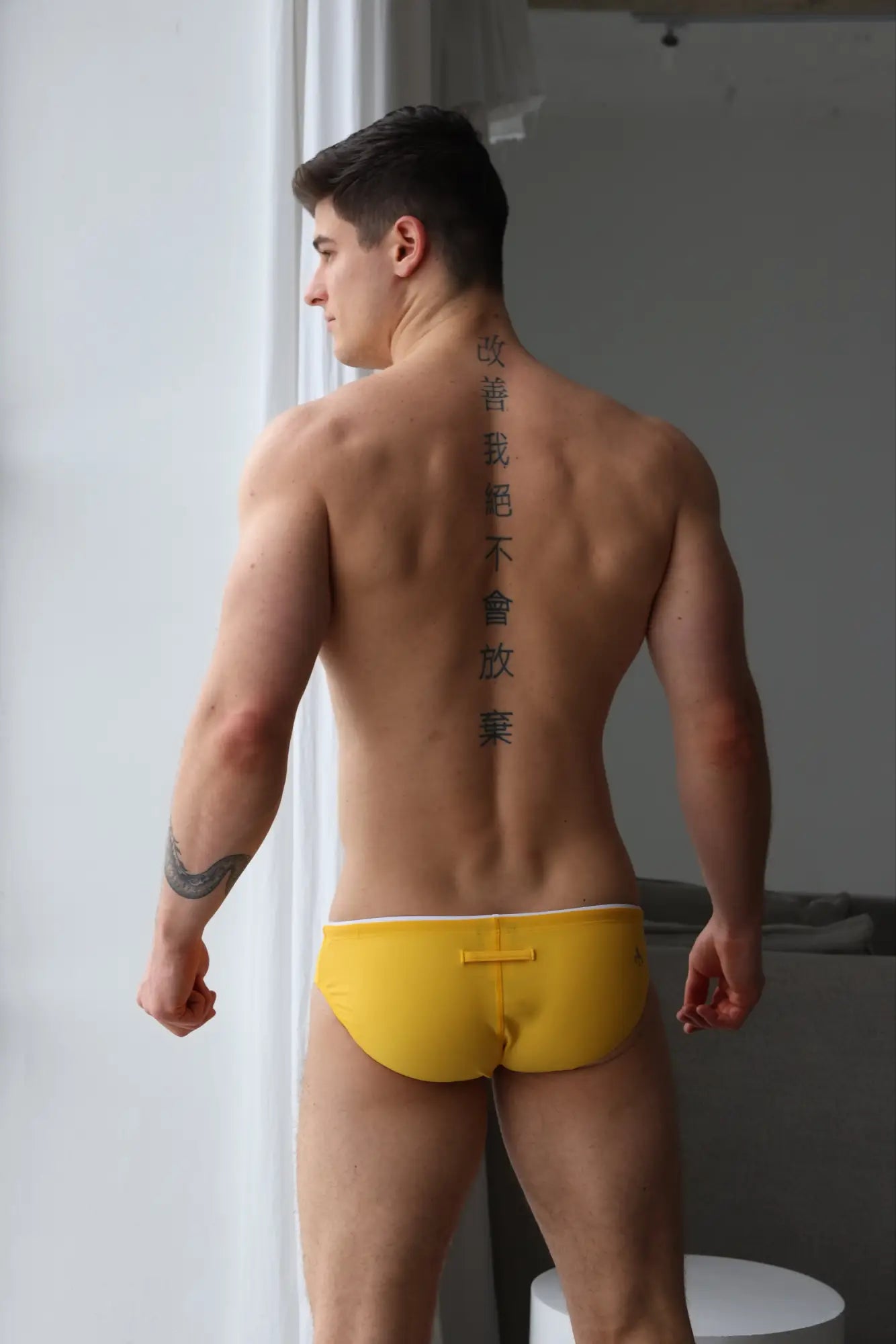 Yellow marcuse sandboy bikini briefs with white trim and central button closure designed for swimwear use