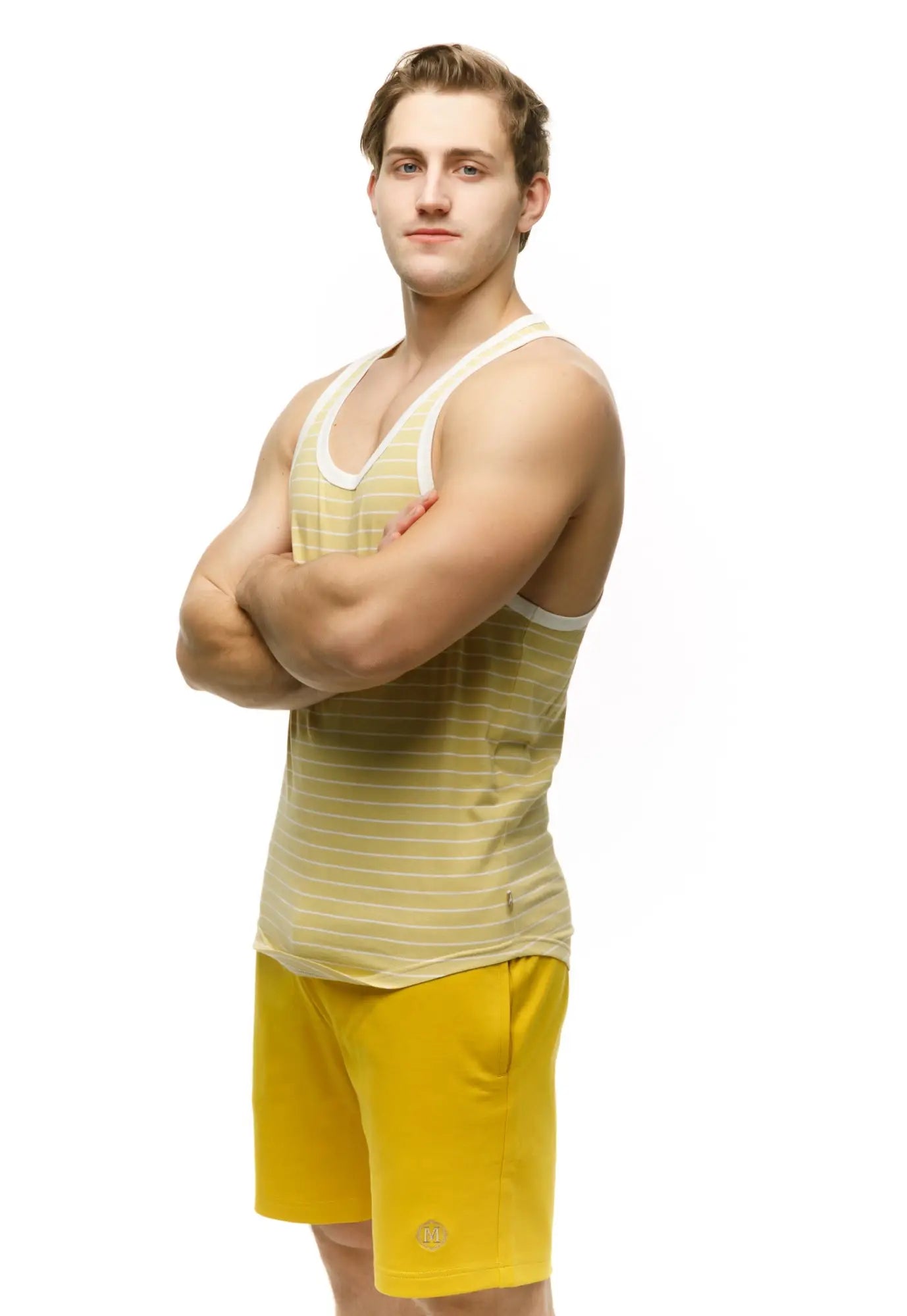 A man wearing a marcuse somer tank top in yellow and white stripes with white trim showing the front view