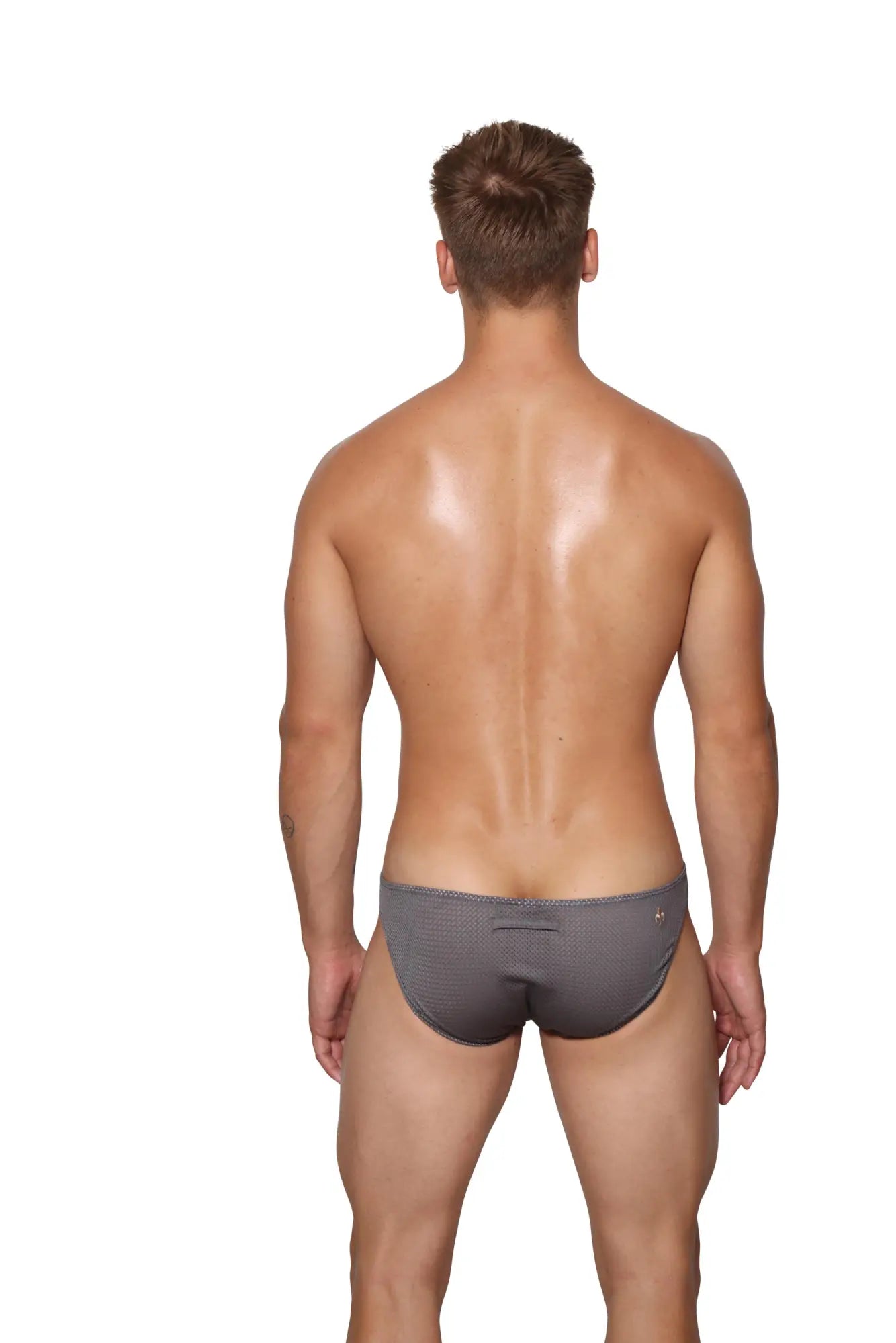 Back view of marcuse tahiti brief underwear in gray textured fabric with subtle pattern and small logo on the back