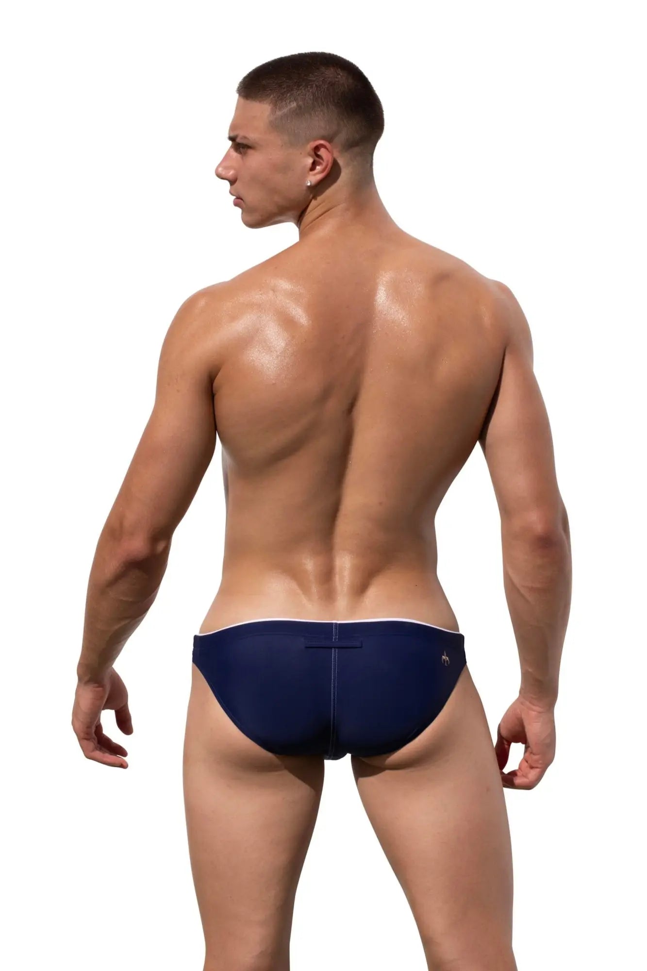 Back view of navy blue Marcuse Wonderland bikini swimwear swim trunks with white trim and a small logo on the back