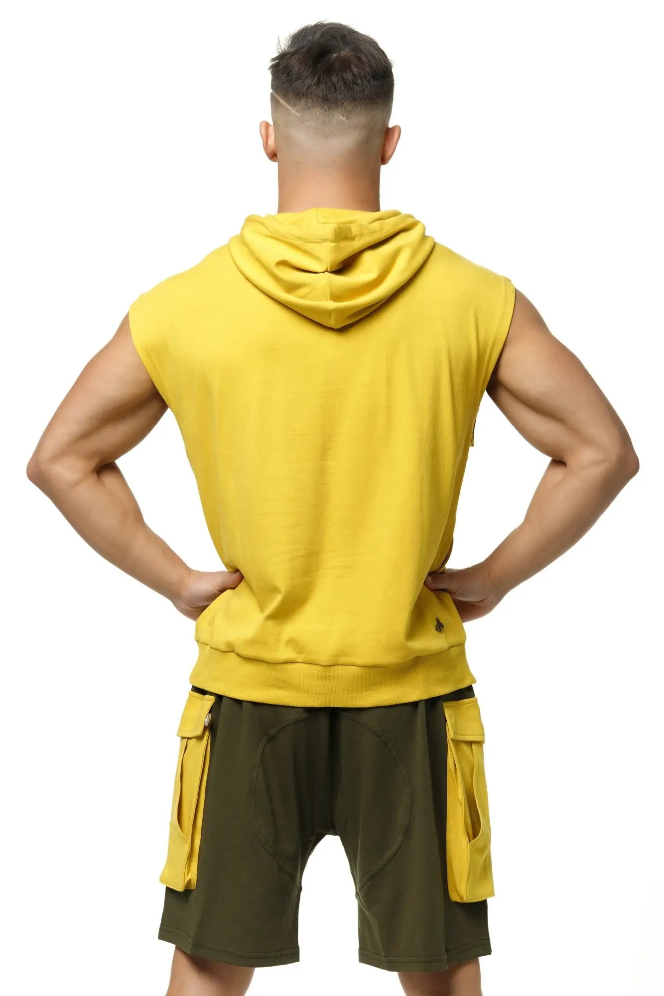 Marcuse Zaiden hoodie tank top in bright yellow sleeveless design with hood and ribbed hem paired with olive green shorts