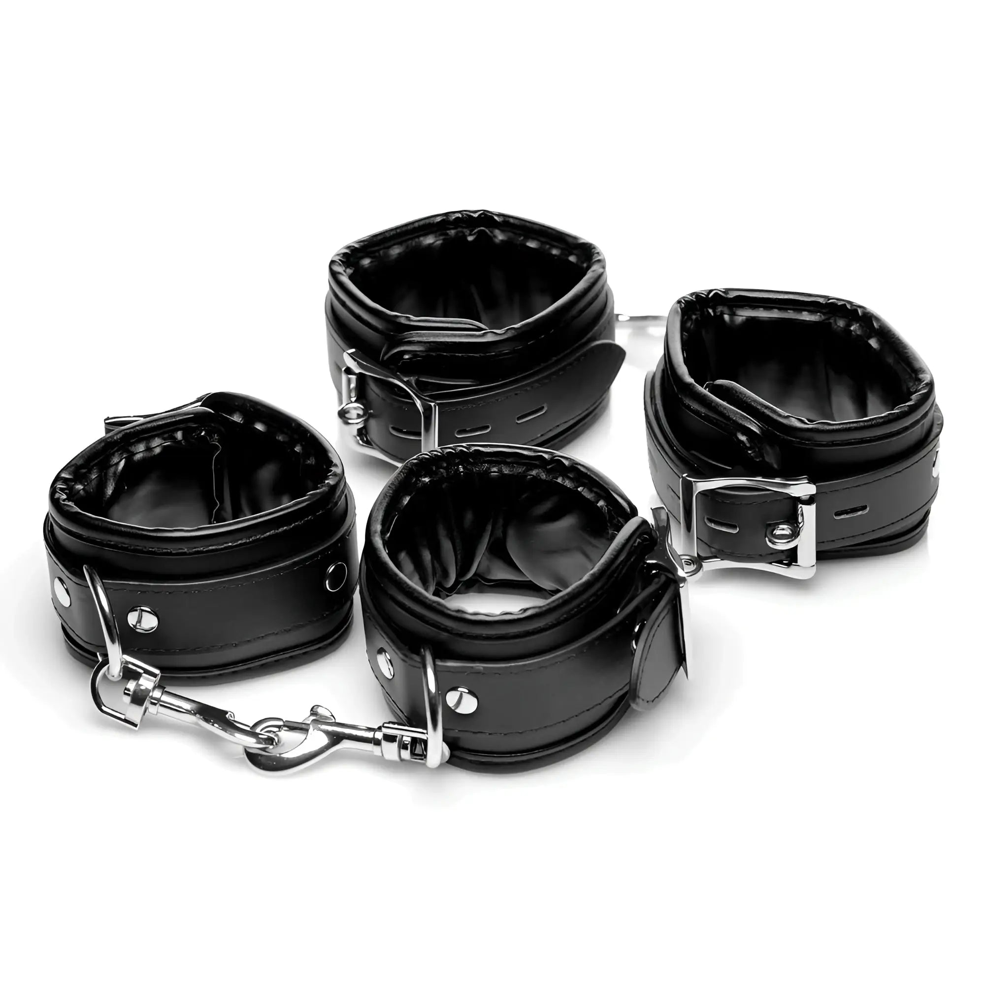 Set of four black leather wrist cuffs with silver metal buckles and chain connectors for master series extreme bondage table