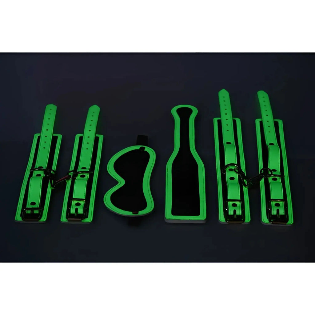 Glowing green leather bondage set with adjustable straps and metal hardware from Master Series Kink In the Dark