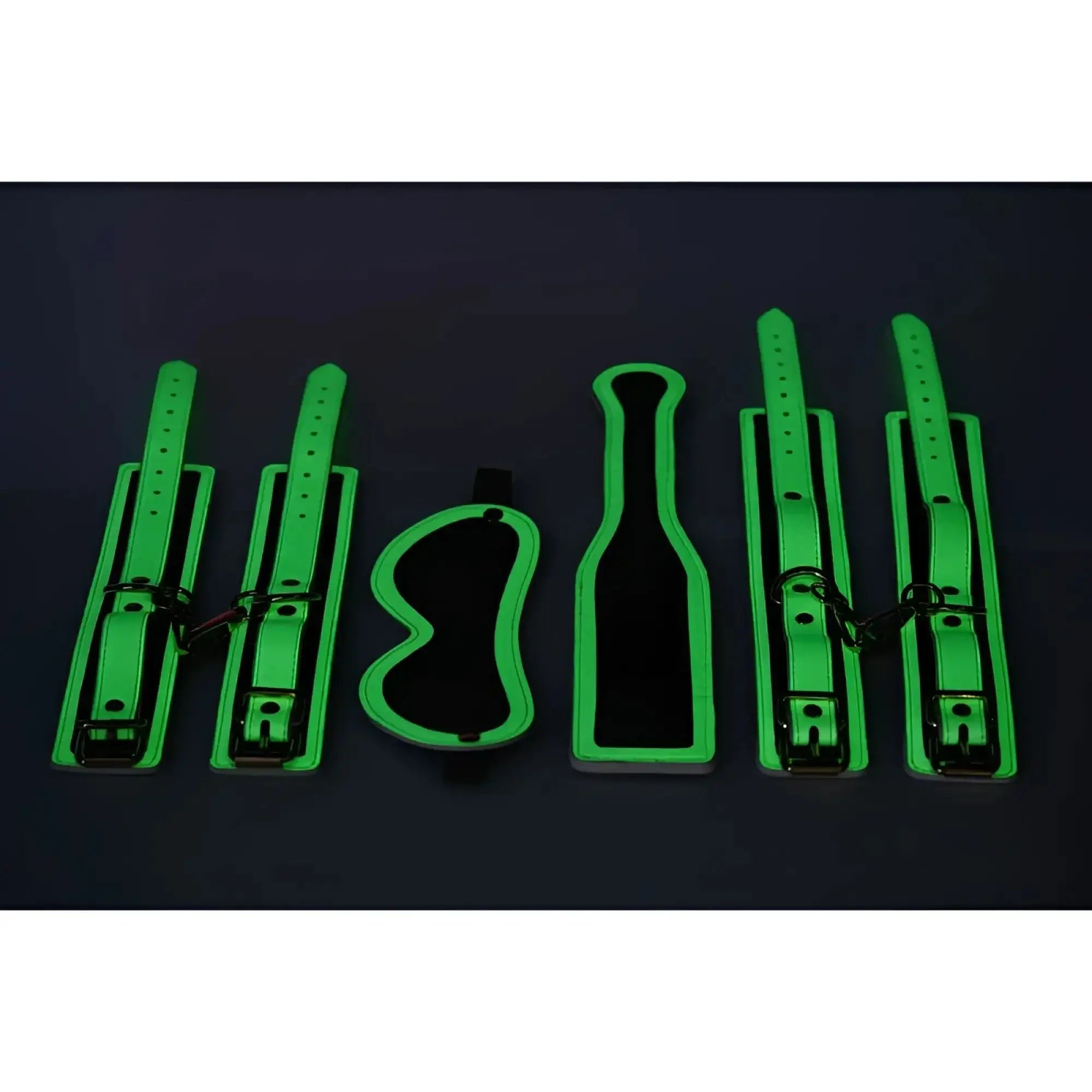 Glowing green leather bondage set with adjustable straps and metal hardware from Master Series Kink In the Dark