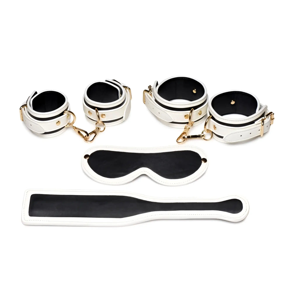 White leather bondage set with black accents and gold-tone hardware from master series kink in the dark glowing fluro green collection