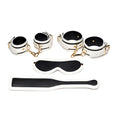 White leather bondage set with black accents and gold-tone hardware from master series kink in the dark glowing fluro green collection
