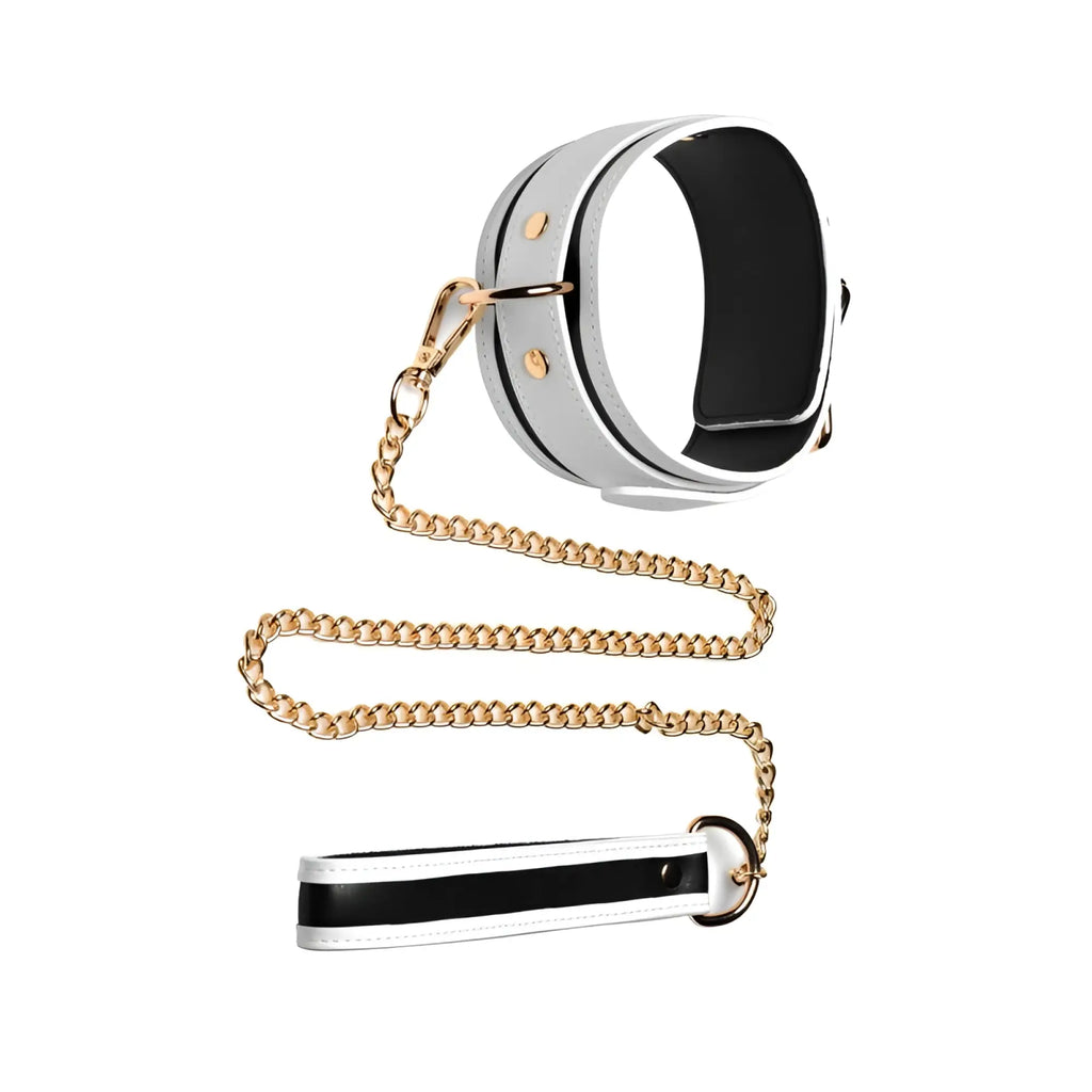 White leather collar with black interior and gold hardware connected to a matching leash by gold chain in master series