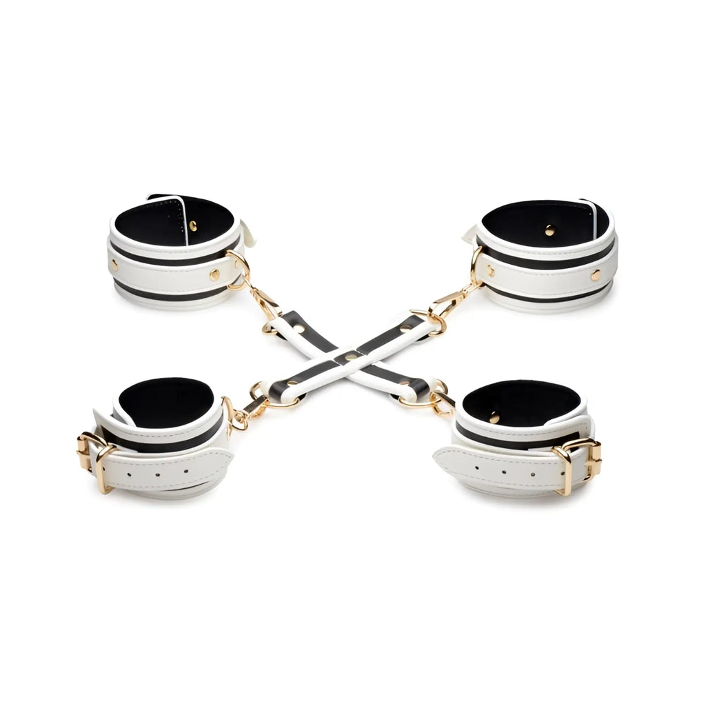 White leather handcuffs with black stripes and gold hardware connected by cross-shaped chain in kink in the dark set