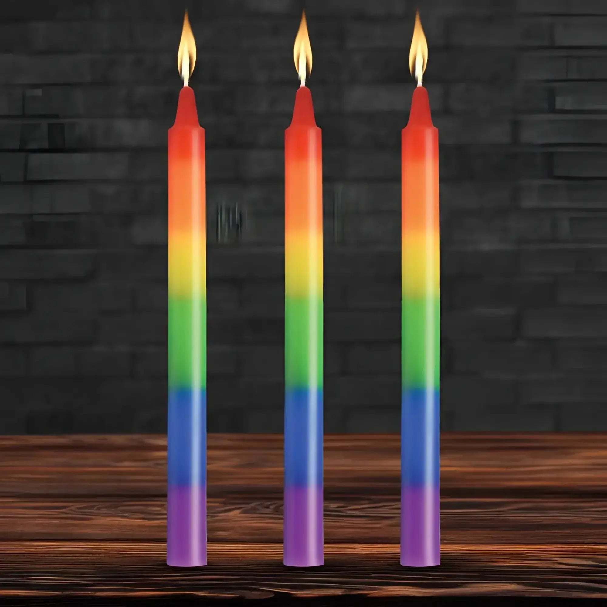 Three slender rainbow-colored taper candles with smooth gradient wax and flickering flames for pride celebration