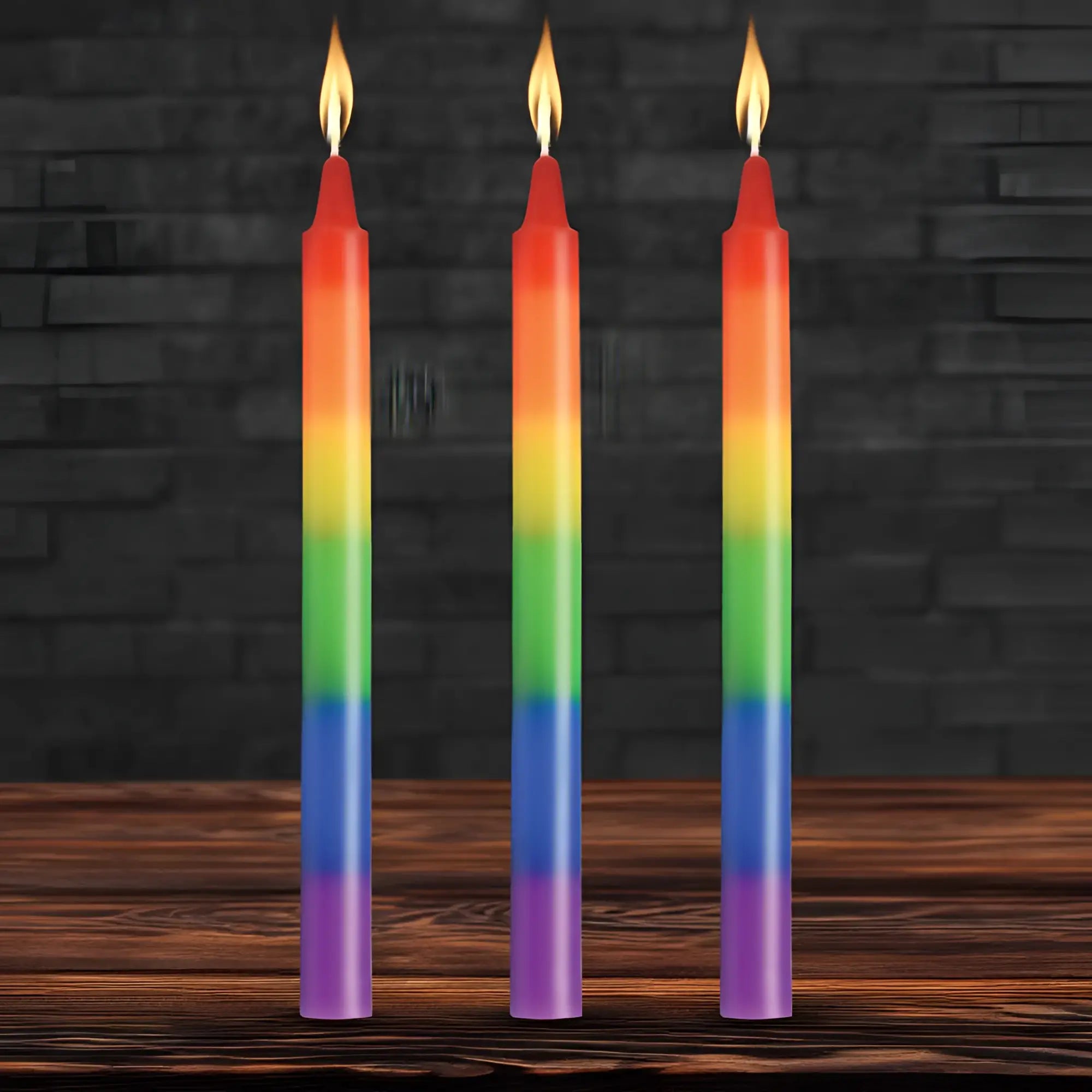 Three slender rainbow-colored taper candles with smooth gradient wax and flickering flames for pride celebration