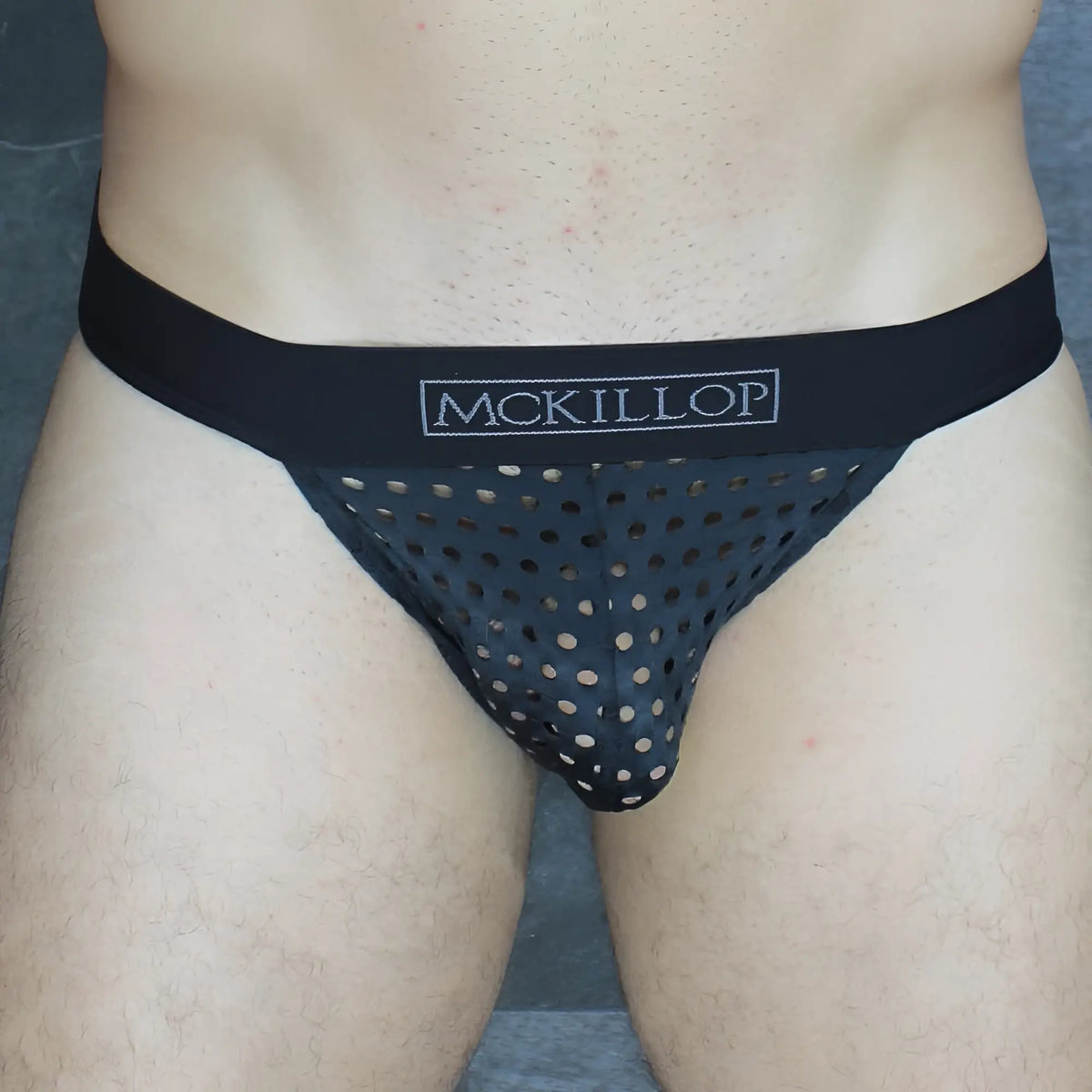 Black mckillop thong brief with perforated mesh design and solid elastic waistband in glory lycra fabric