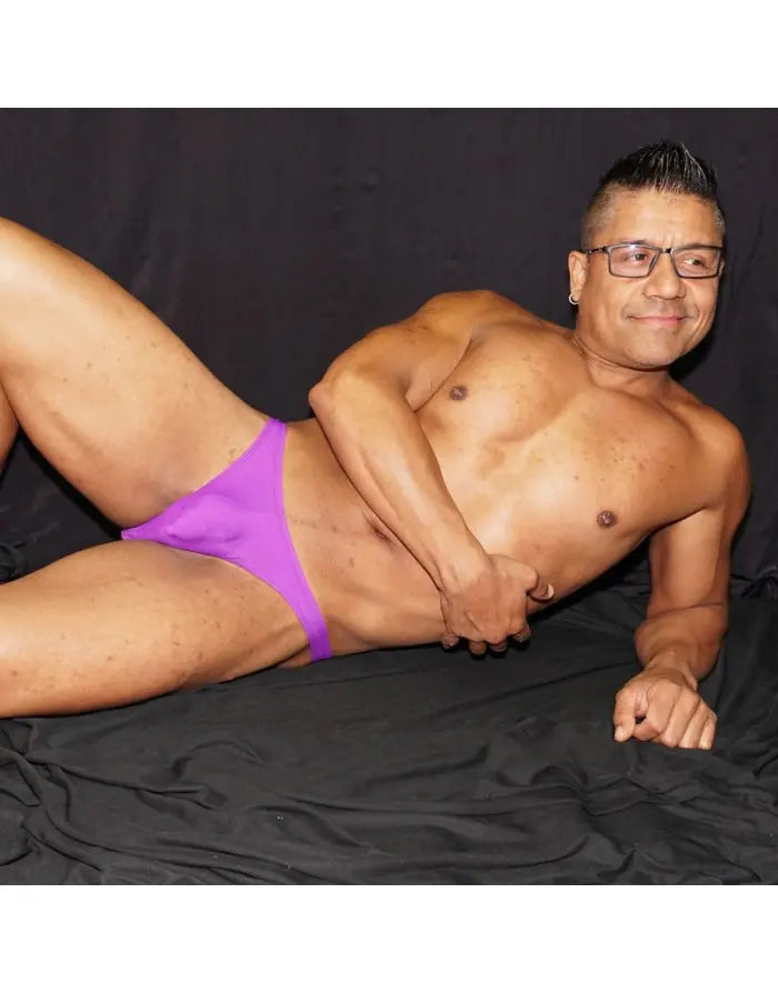 Purple backless bikini underwear by Arroyman featuring a snug fit and minimal coverage modeled by a man.